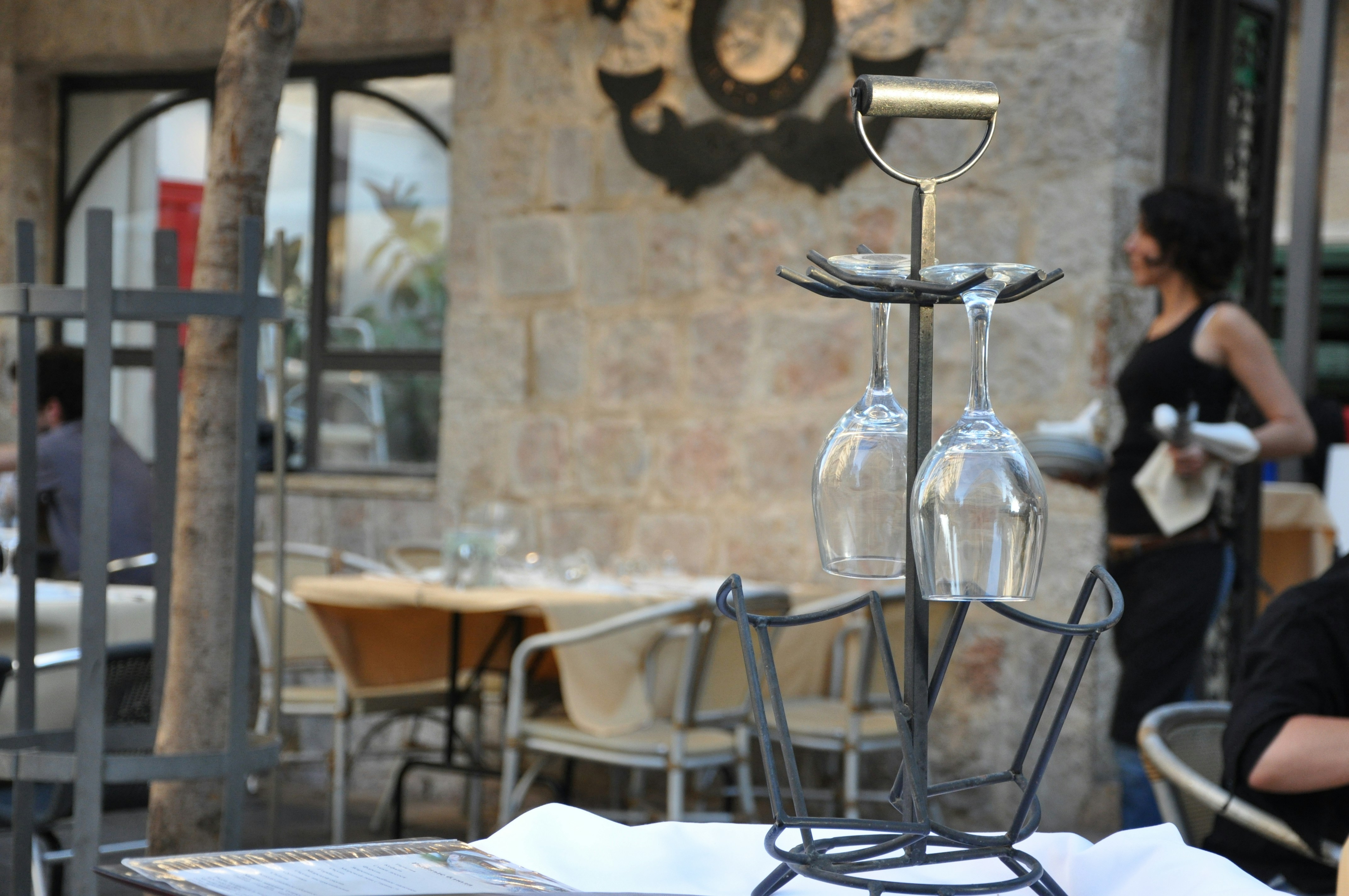 Wine glasses on a metal rack at an outdoor restaurant