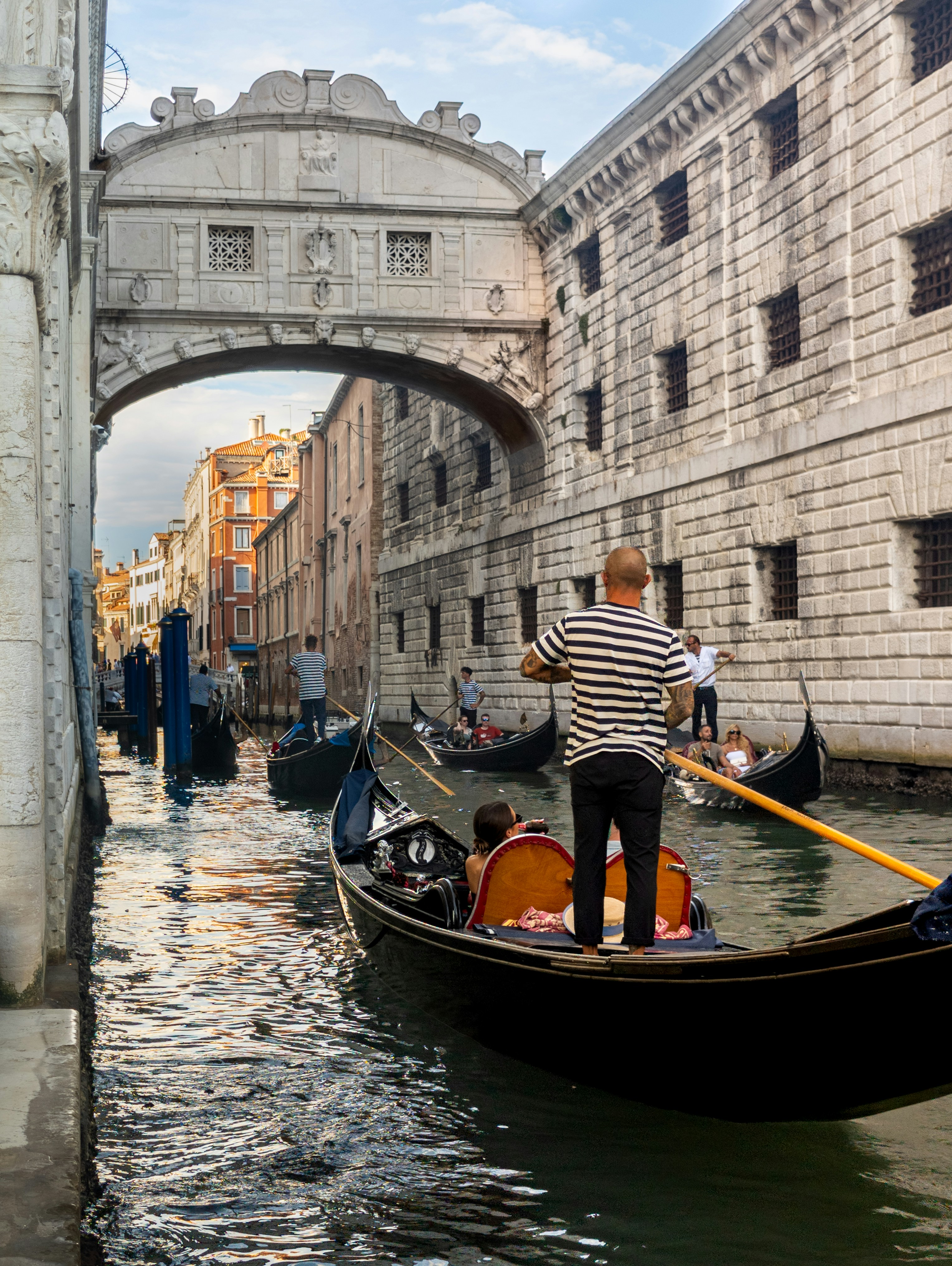 A gondolier steering a gondola under the Bridge of Sighs in Venice