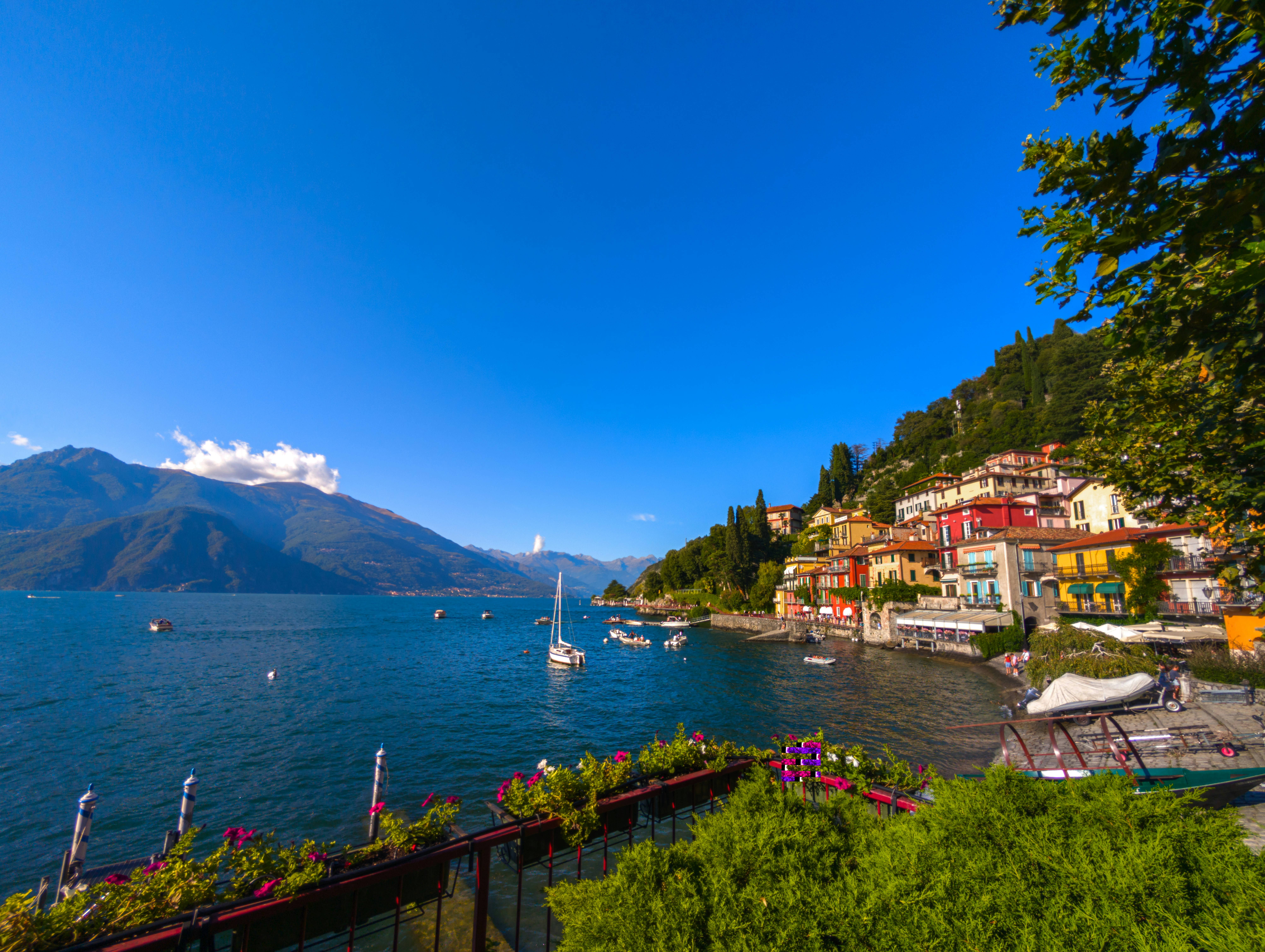 Edificios coloridos a orillas del lago de Como con montañas a lo lejos