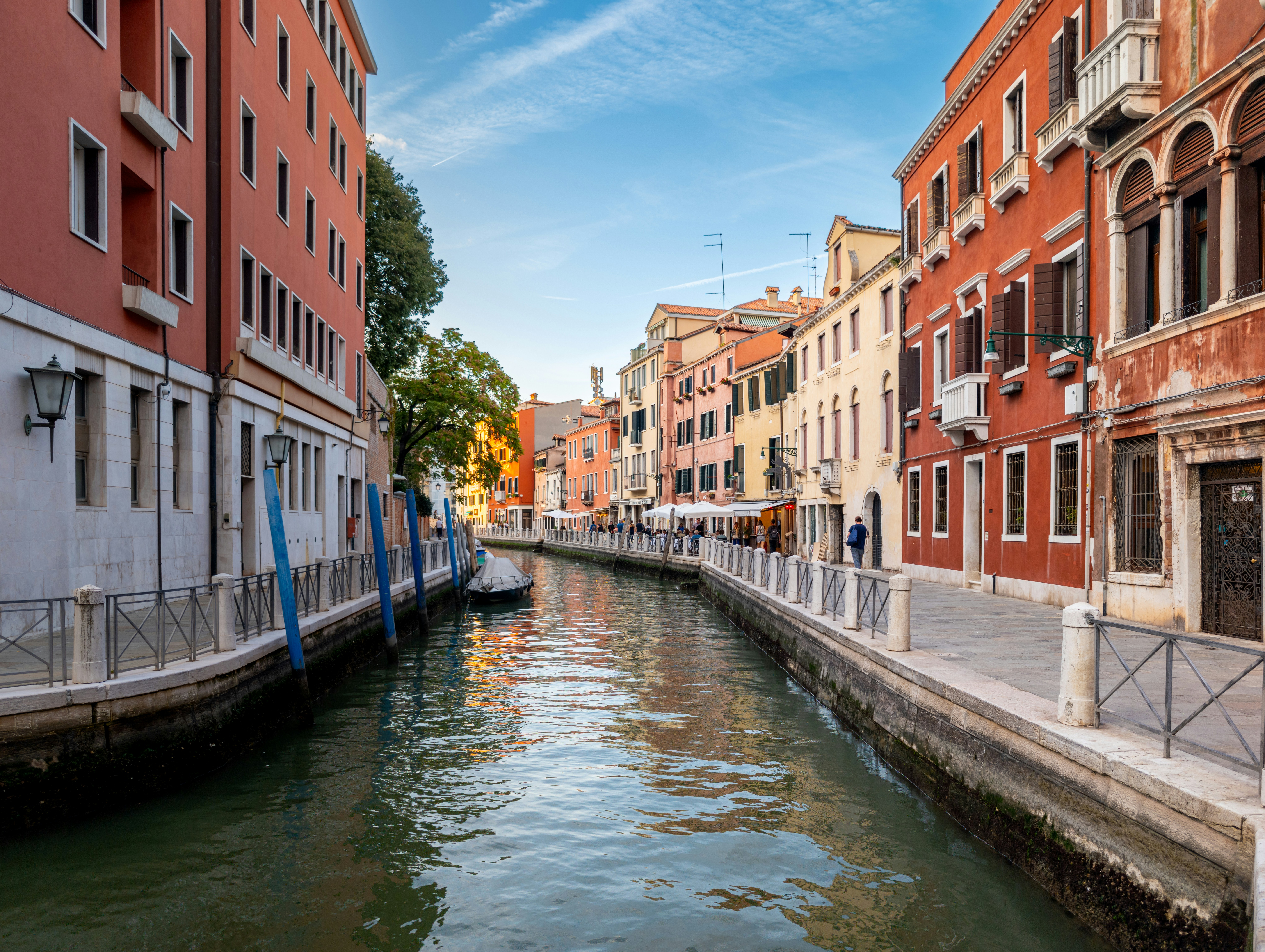 Un canal estrecho bordeado de coloridos edificios históricos y pasarelas de piedra en Venecia
