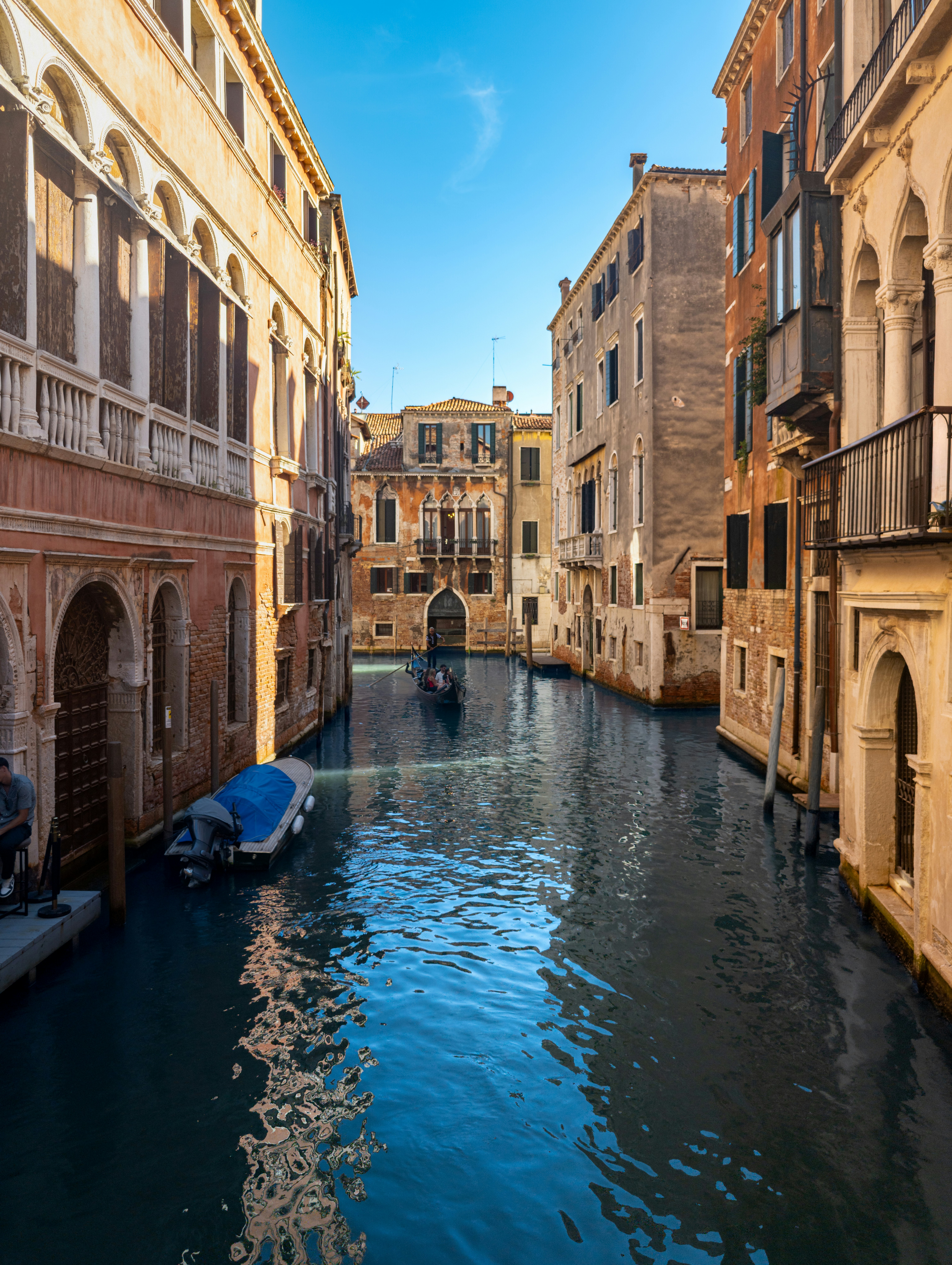 Una góndola en un canal estrecho entre edificios históricos de Venecia, Italia