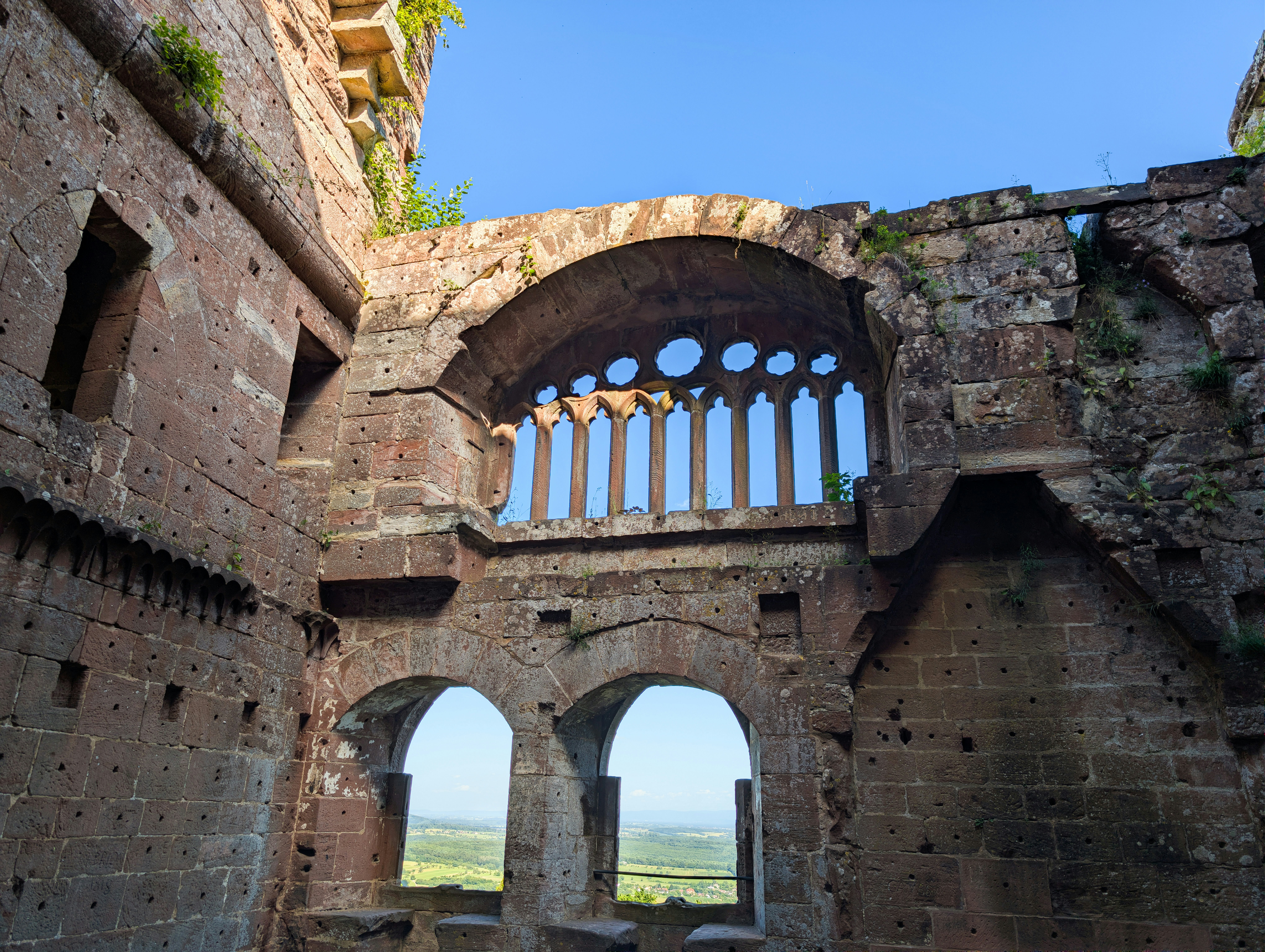 Stone arches and a gothic window in the ruins of a medieval castle
