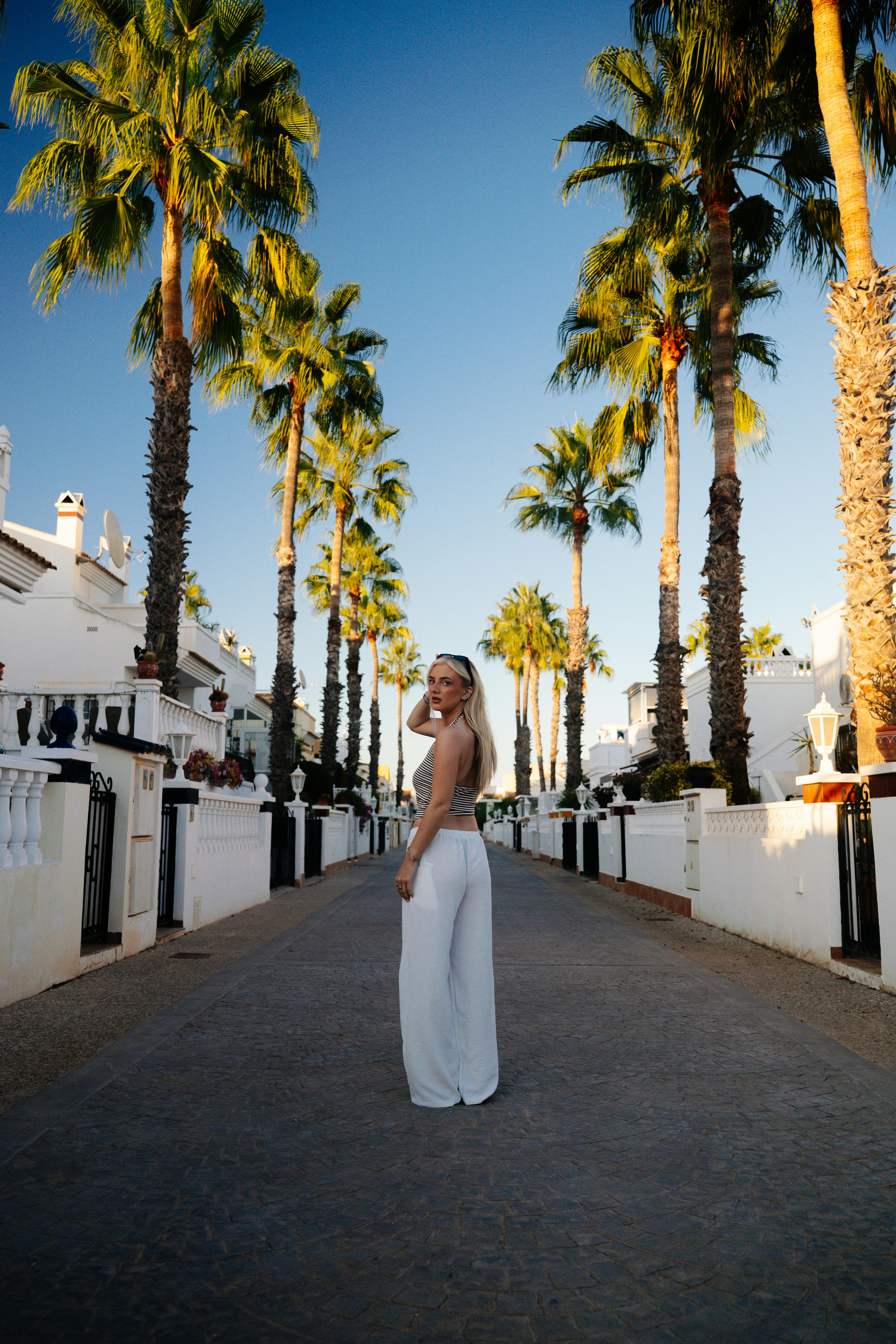 Femme dans la rue bordée de palmiers - Photo gratuite sur Unsplash