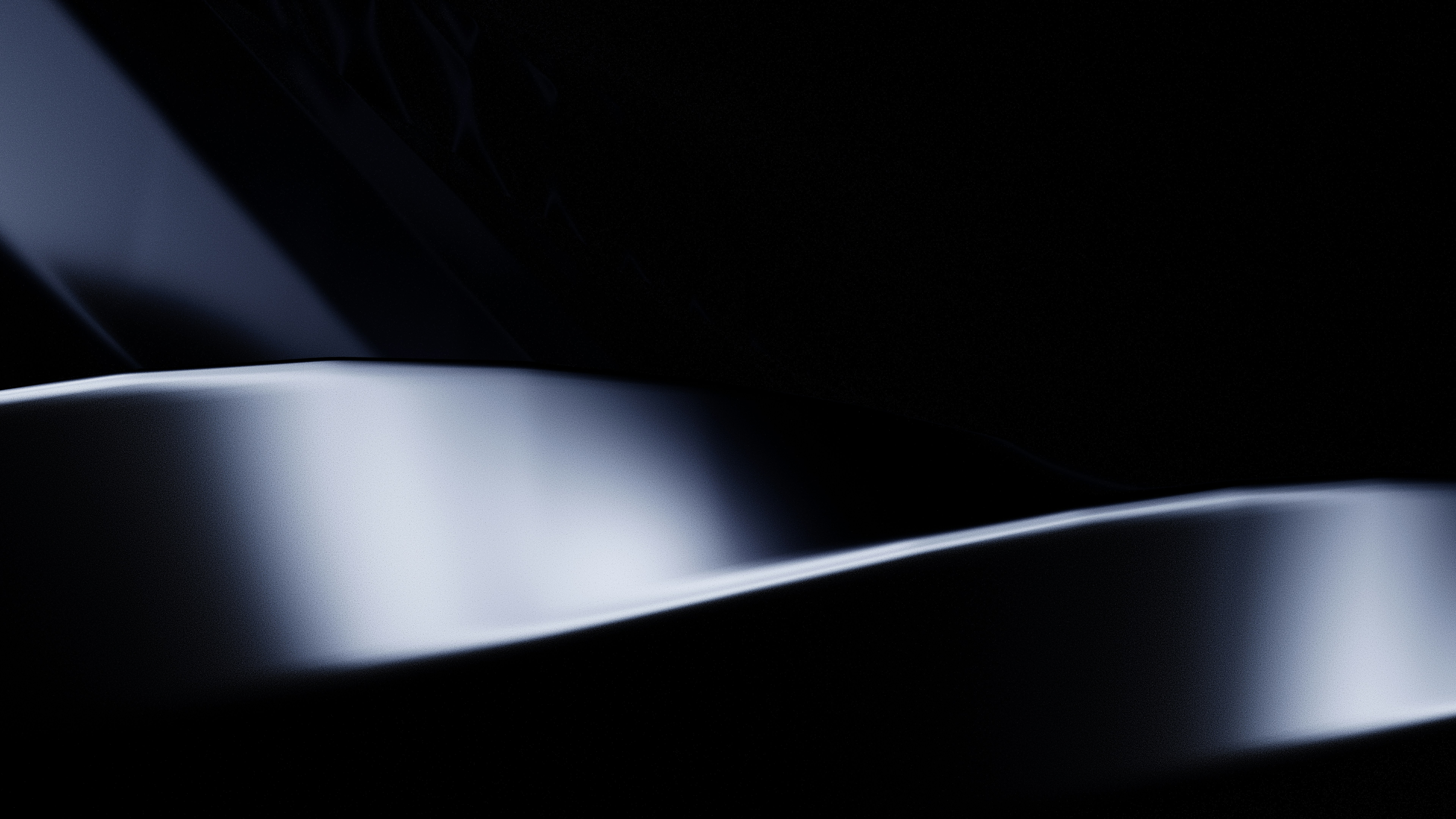 A smooth metallic wave with soft highlights against a dark background
