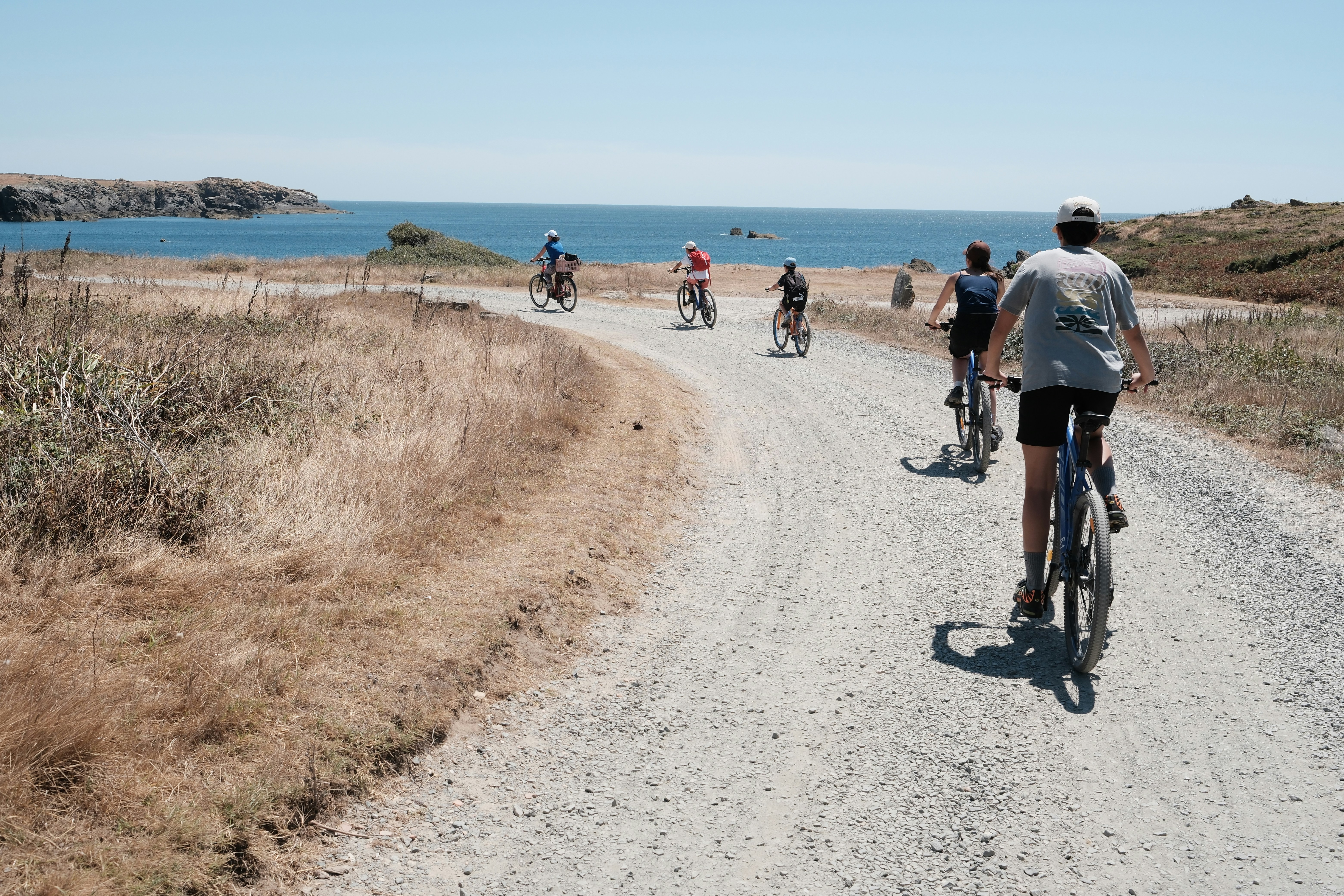 Group of riders on a gravel path by the sea