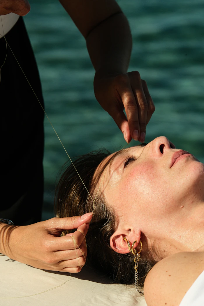 Beautician threading a client’s eyebrows