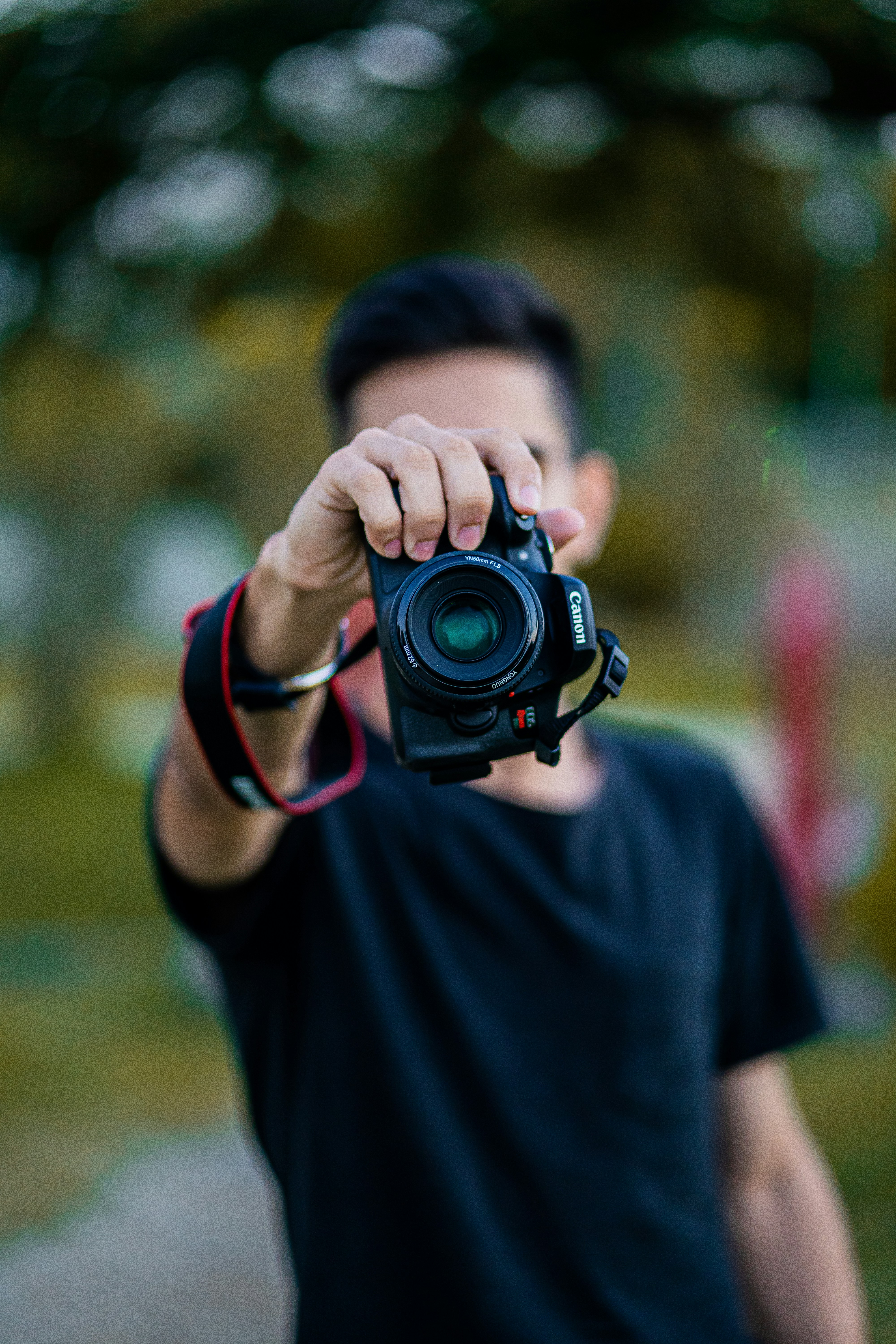 Persona sujetando la cámara con camisa negra - Foto gratuita en Unsplash