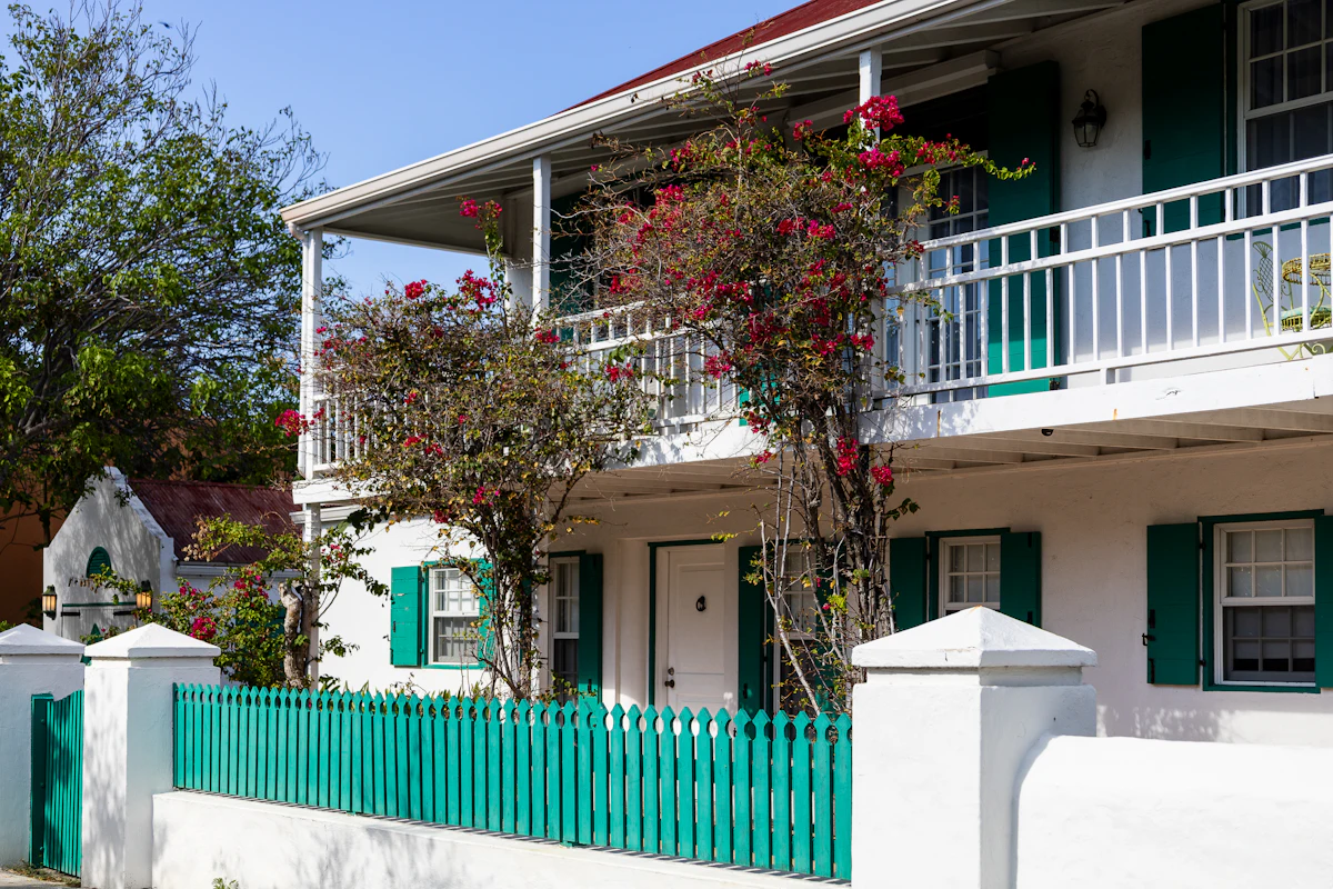 White two-storey house with green shutters (stock placeholder)