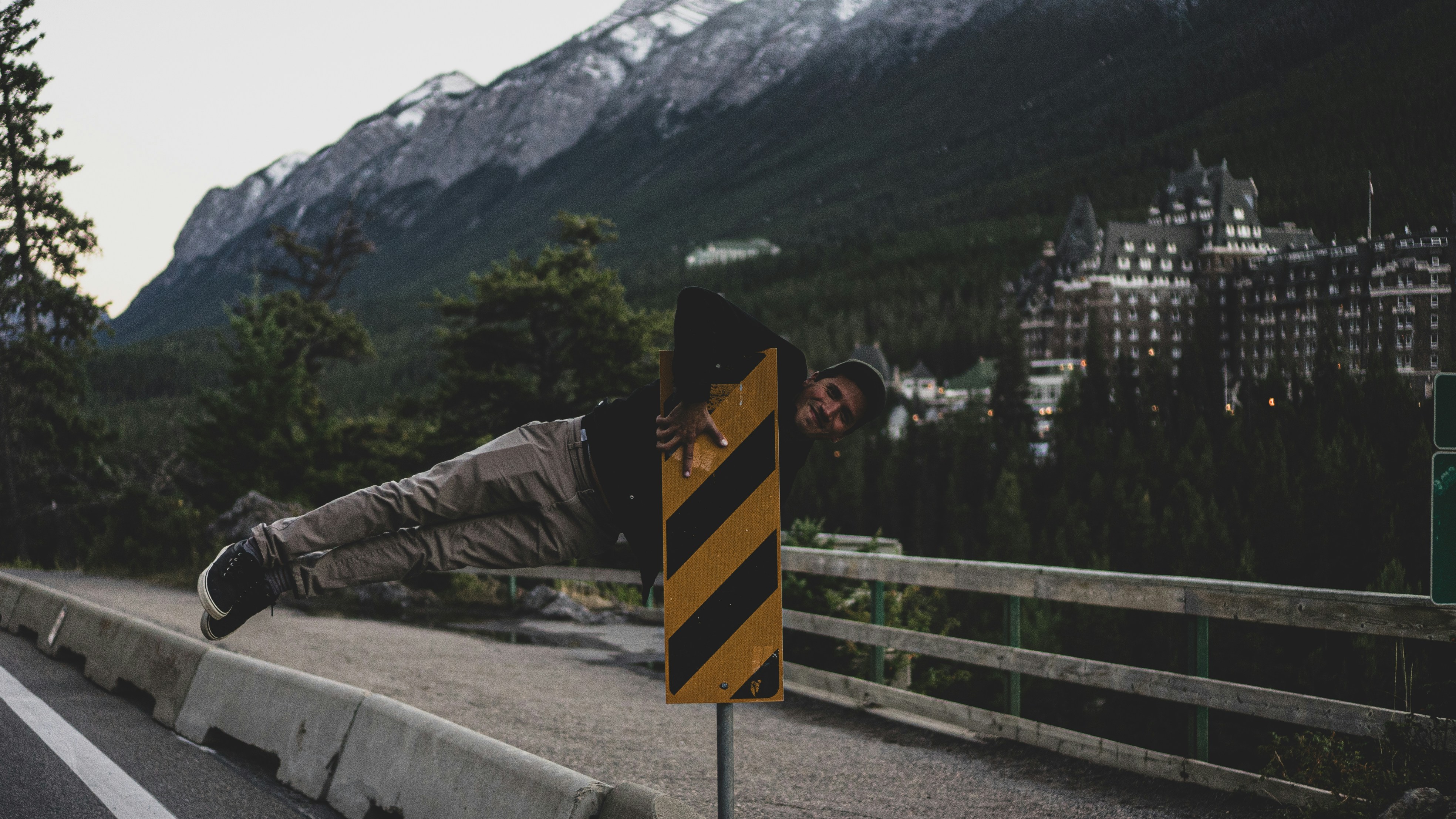 A person holding onto a yellow and black striped road sign in Banff