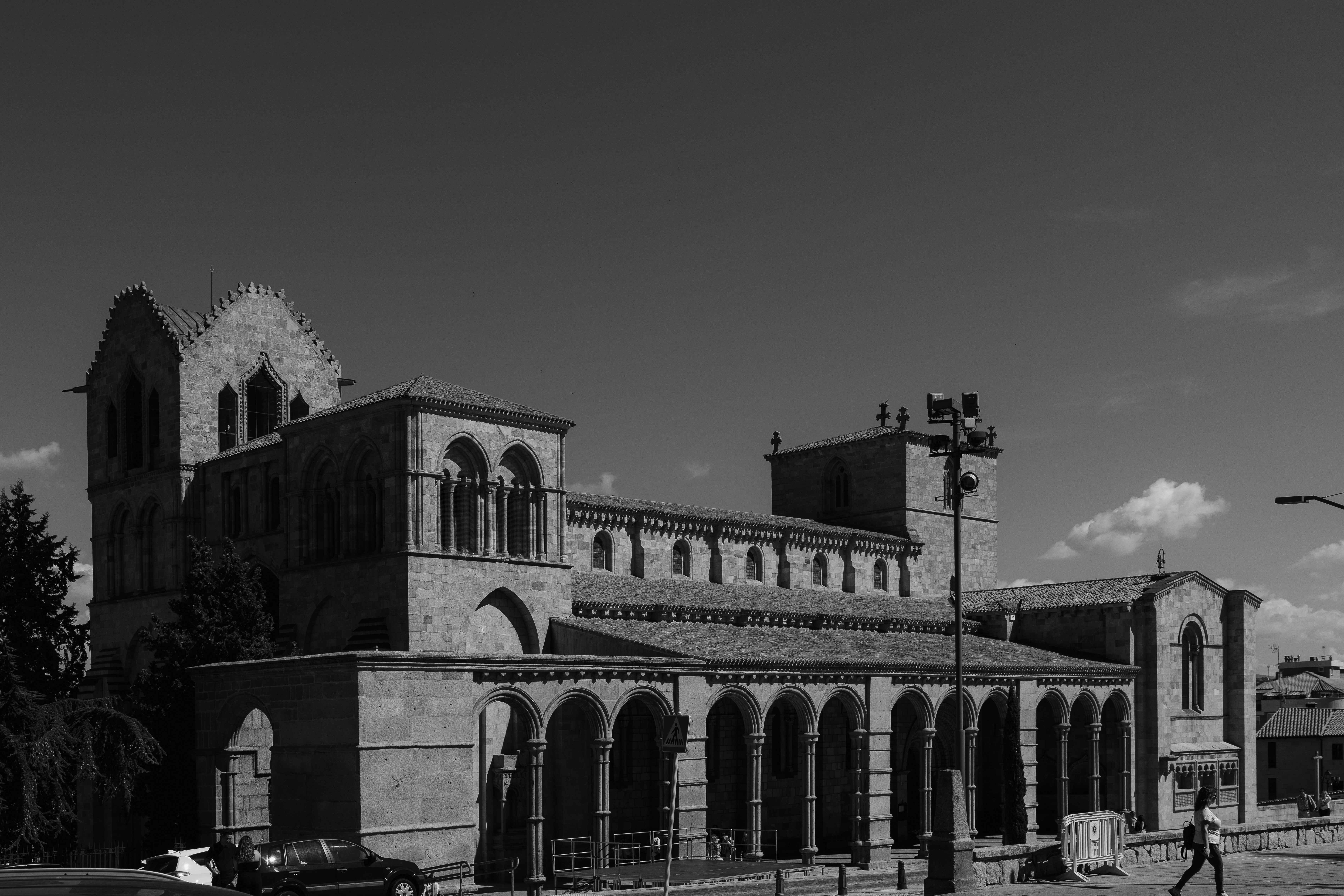 A Romanesque stone church with arched porticos under a clear sky in Avila