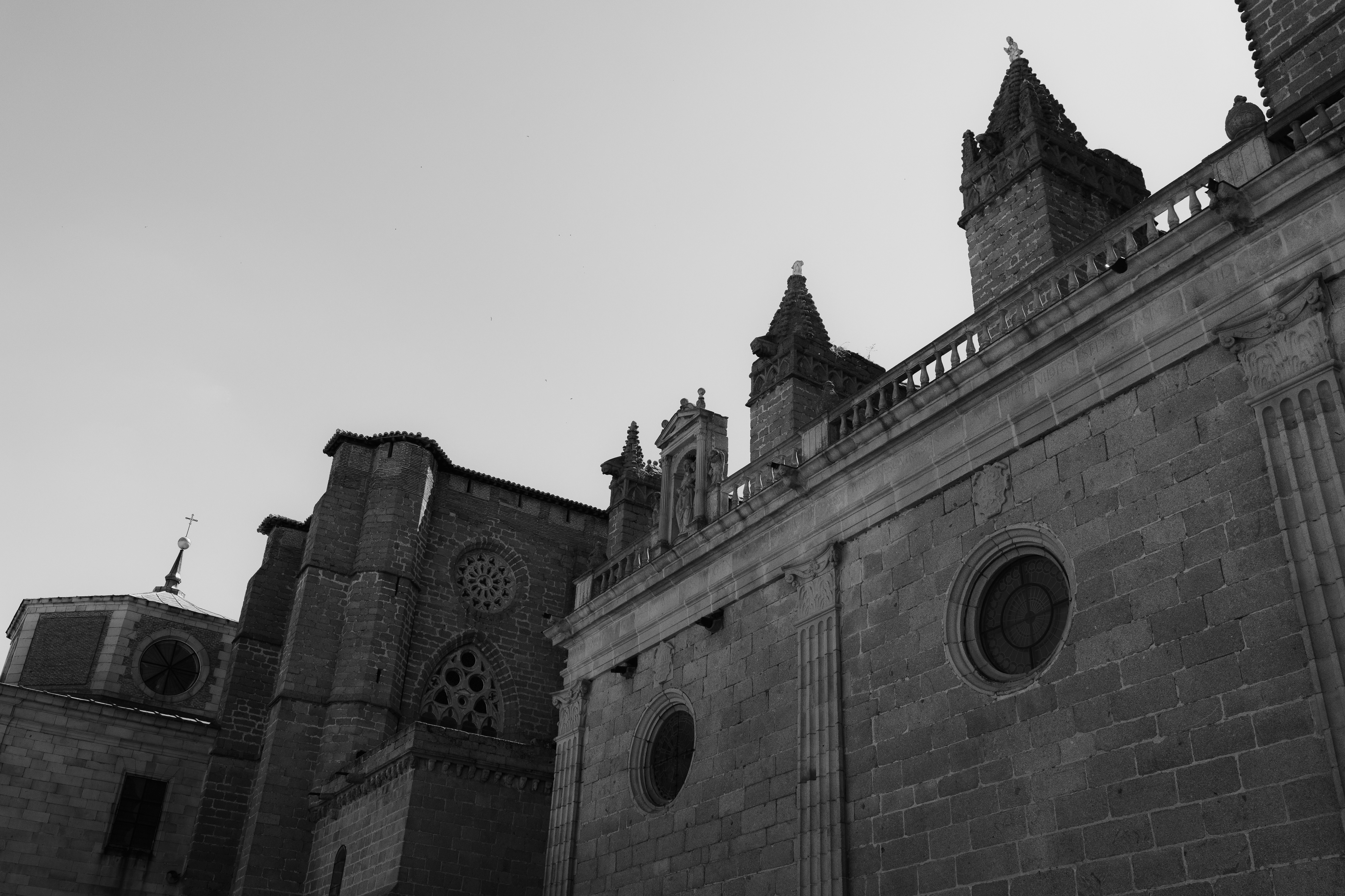 The stone facade and gothic spires of a historic cathedral in black and white