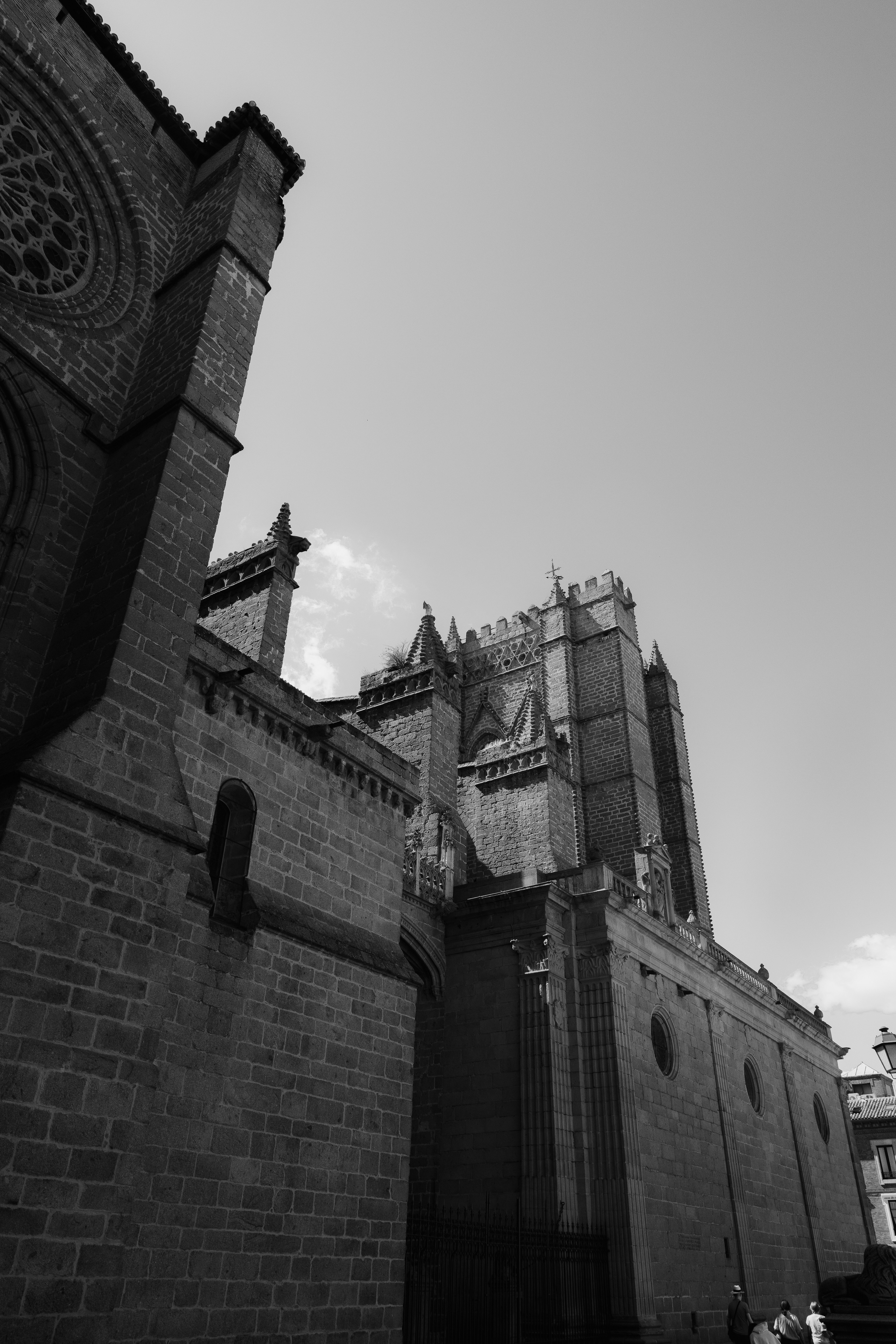 A black and white view of a gothic cathedral with stone buttresses and towers