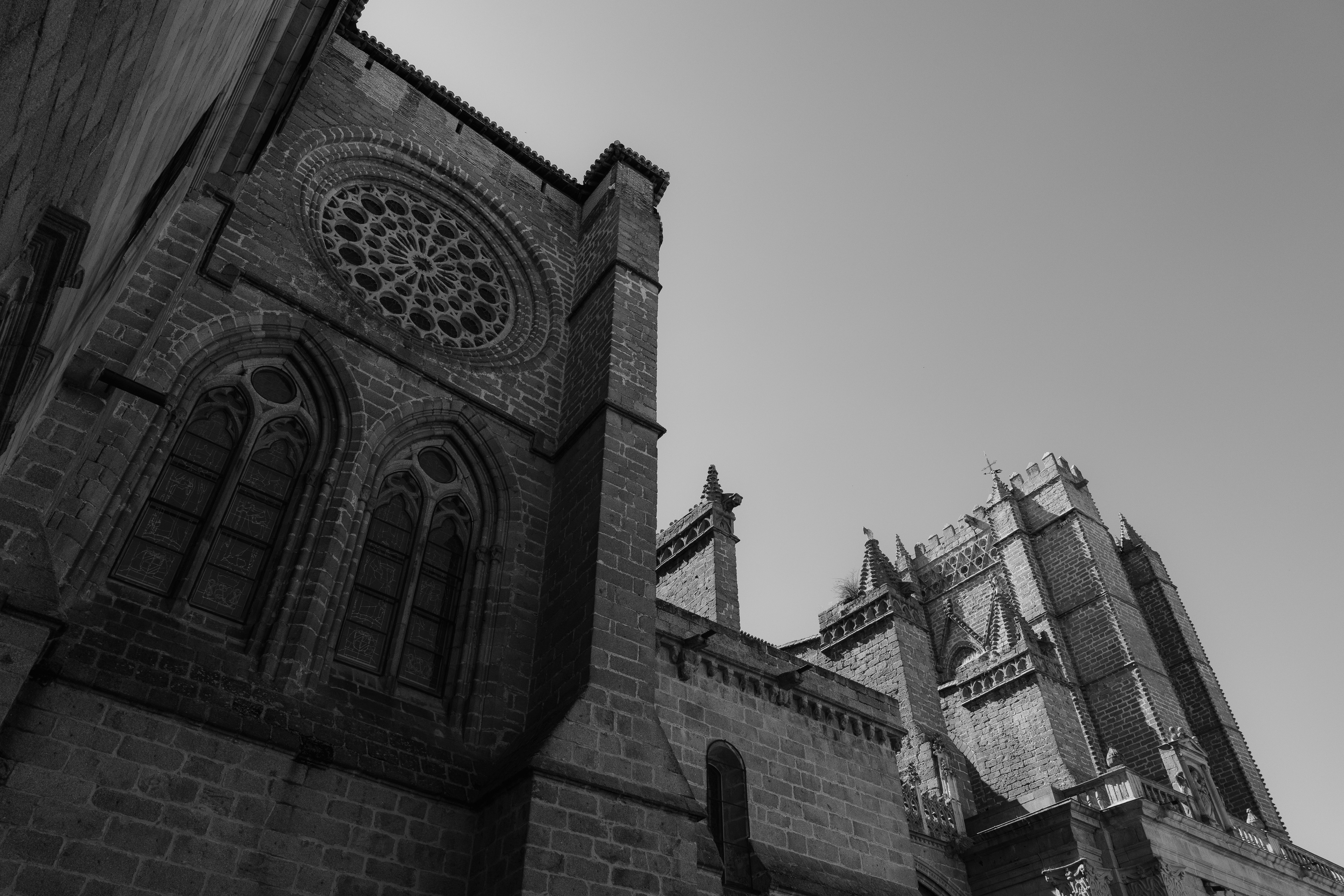 Gothic stone cathedral with a large rose window and pointed arches against clear sky