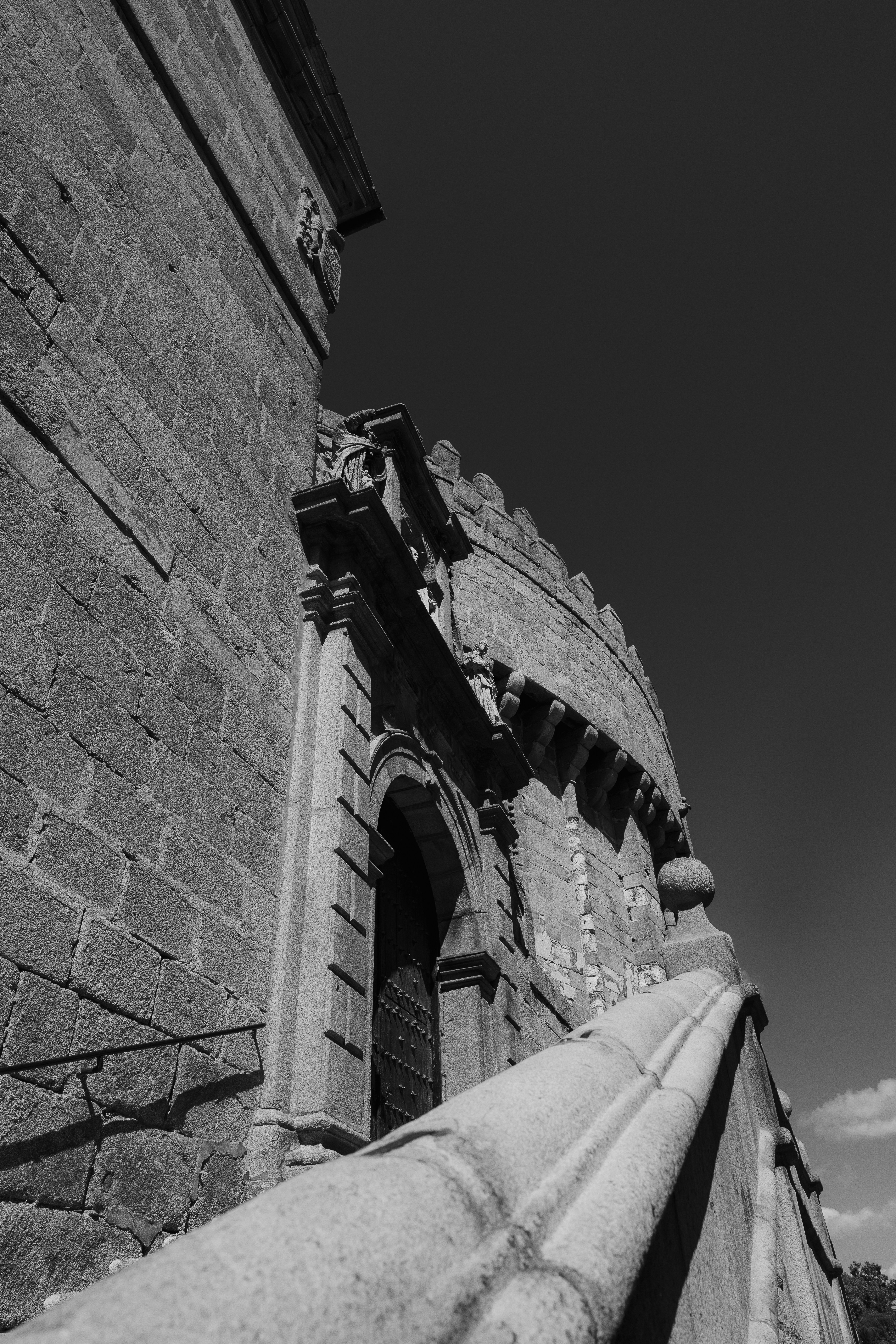 A stone staircase leading to an arched doorway of a historic fortress wall