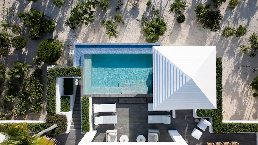 aerial of a pool with white loungers