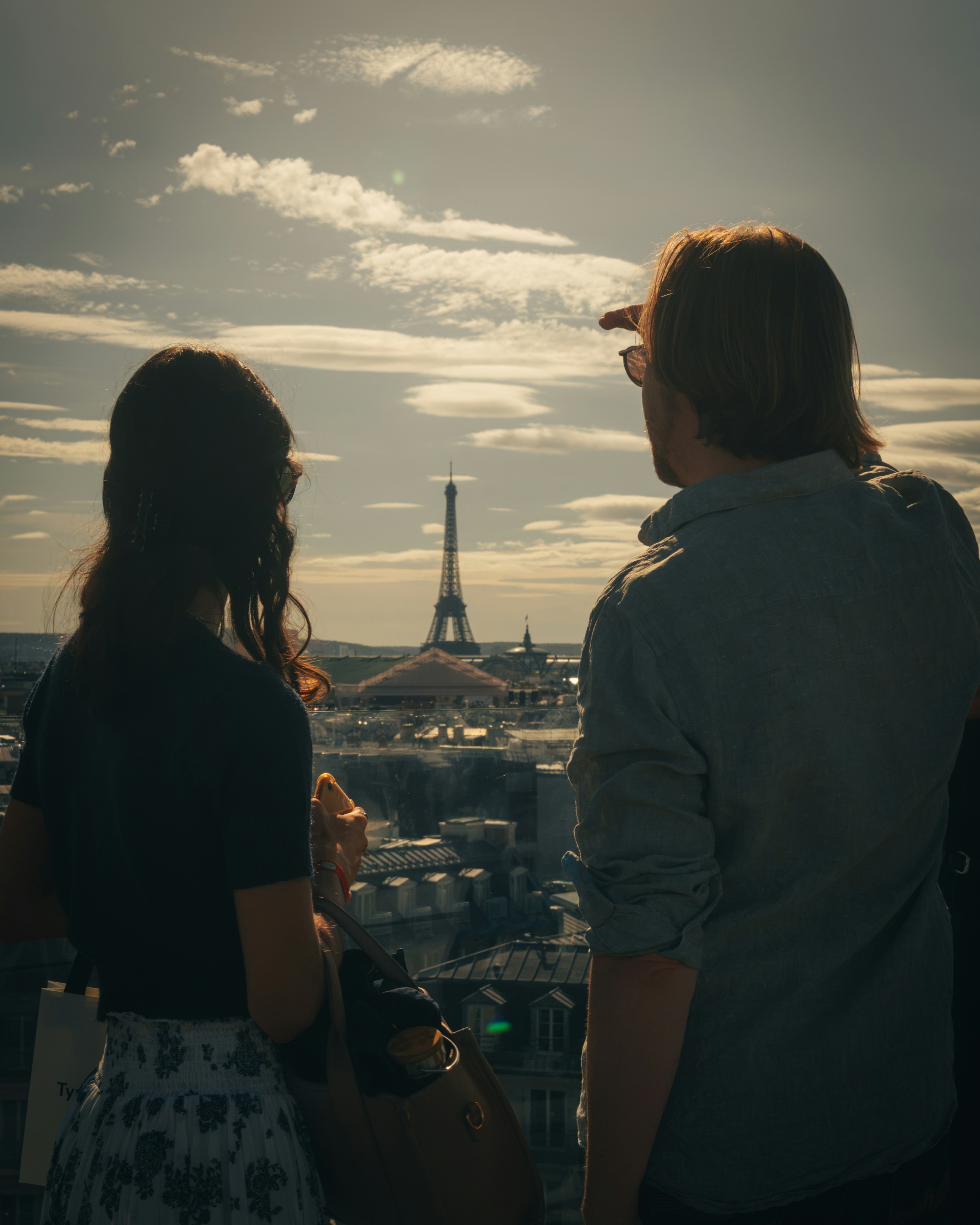 A woman and a man looking at the Eiffel Tower in Paris
