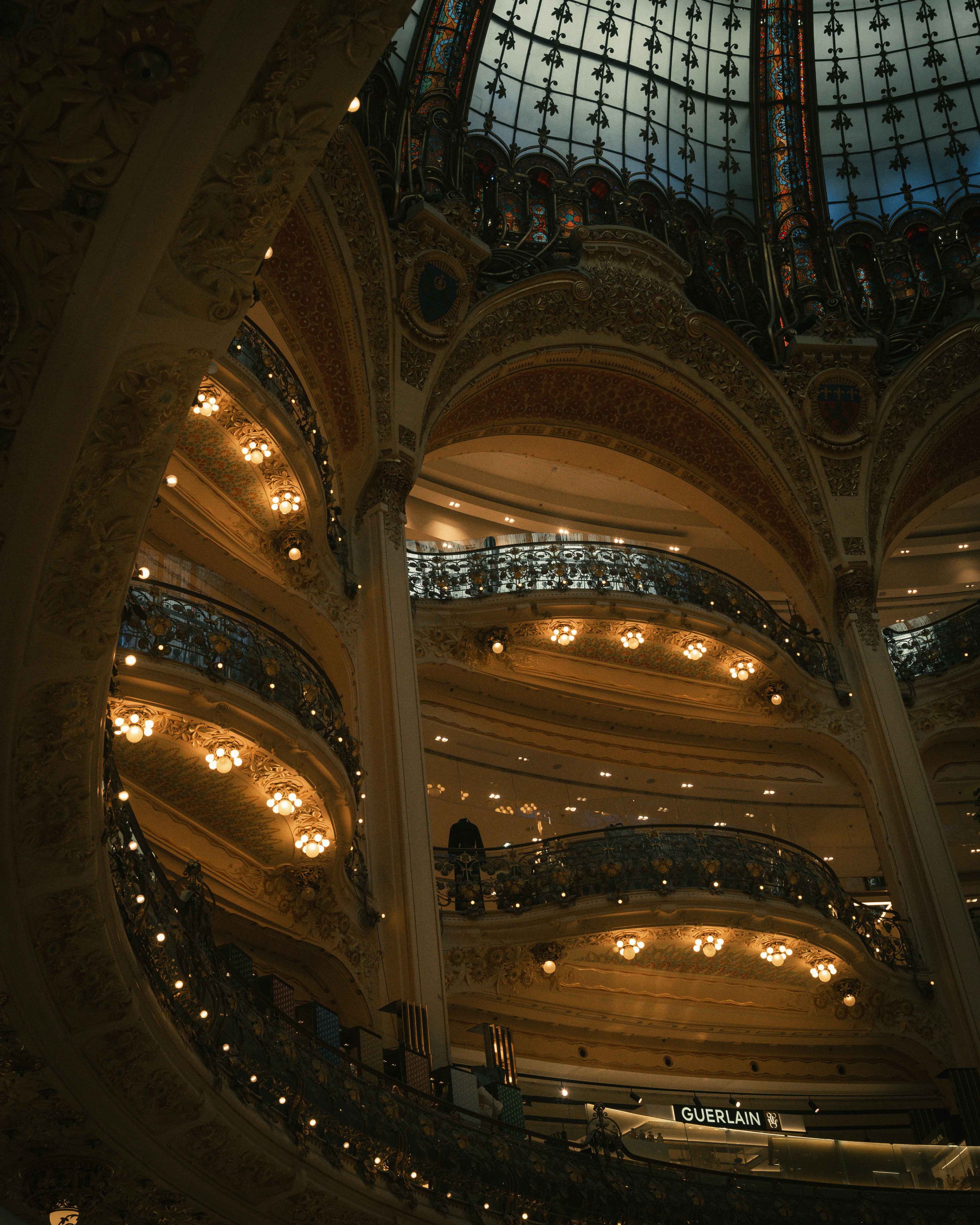 The ornate domed ceiling and tiered balconies of Galeries Lafayette in Paris