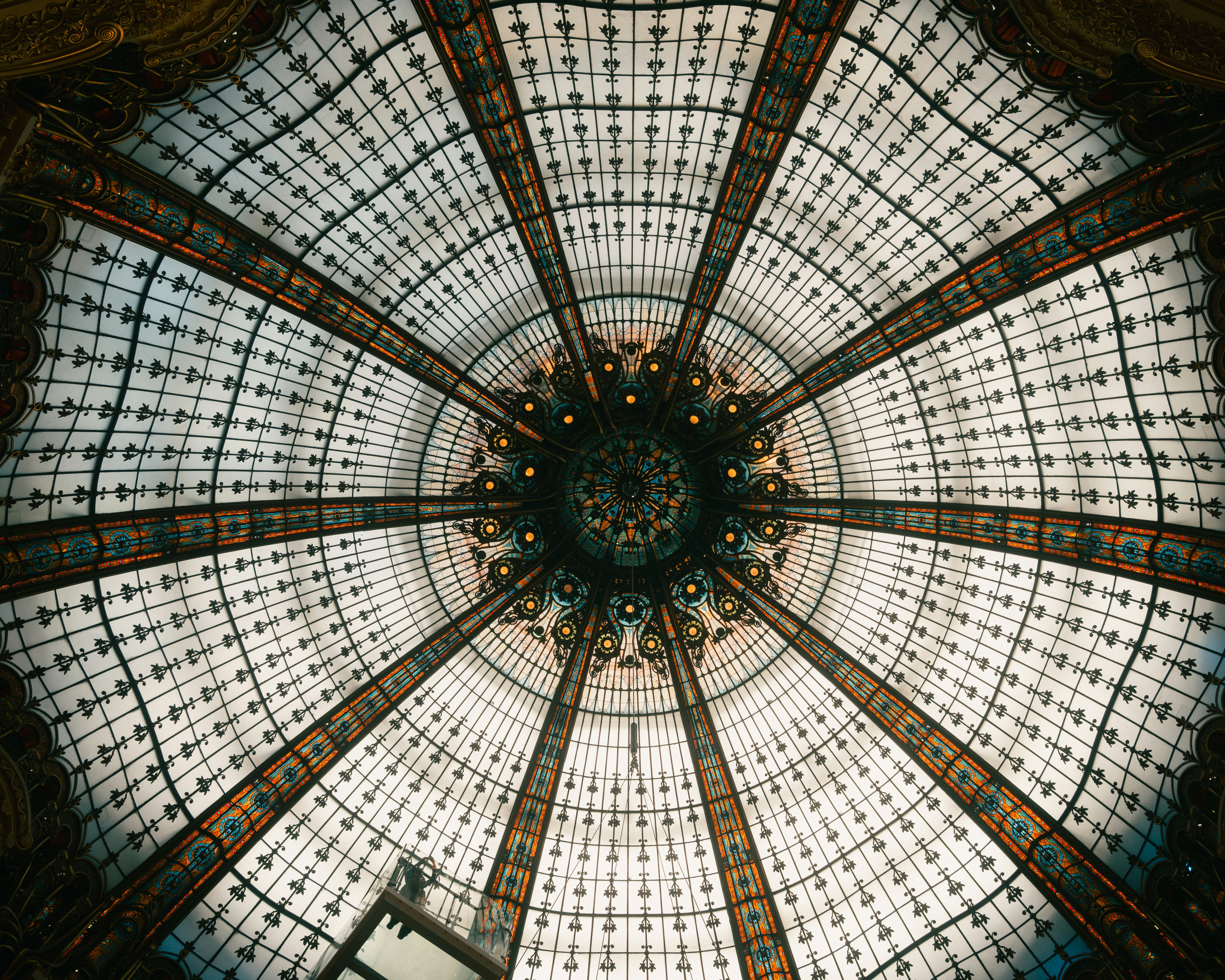 A stained glass dome with intricate metal framework and a central circular pattern