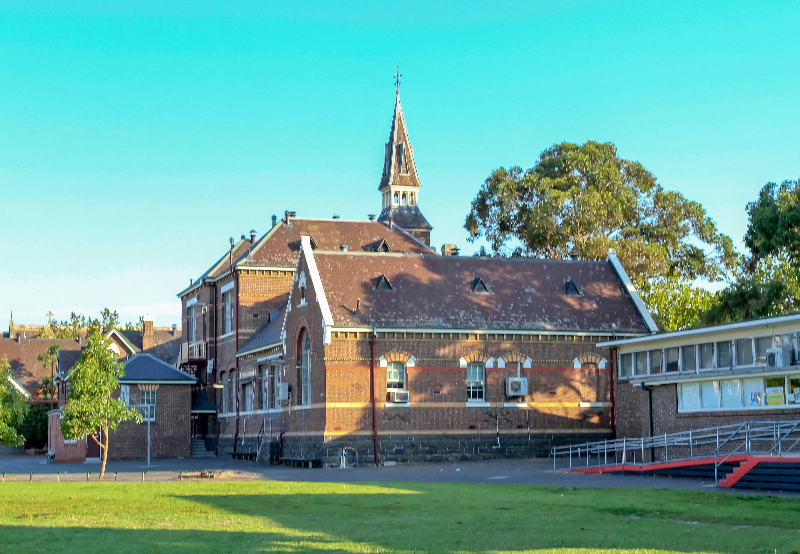 Historic red-brick school building with a spire