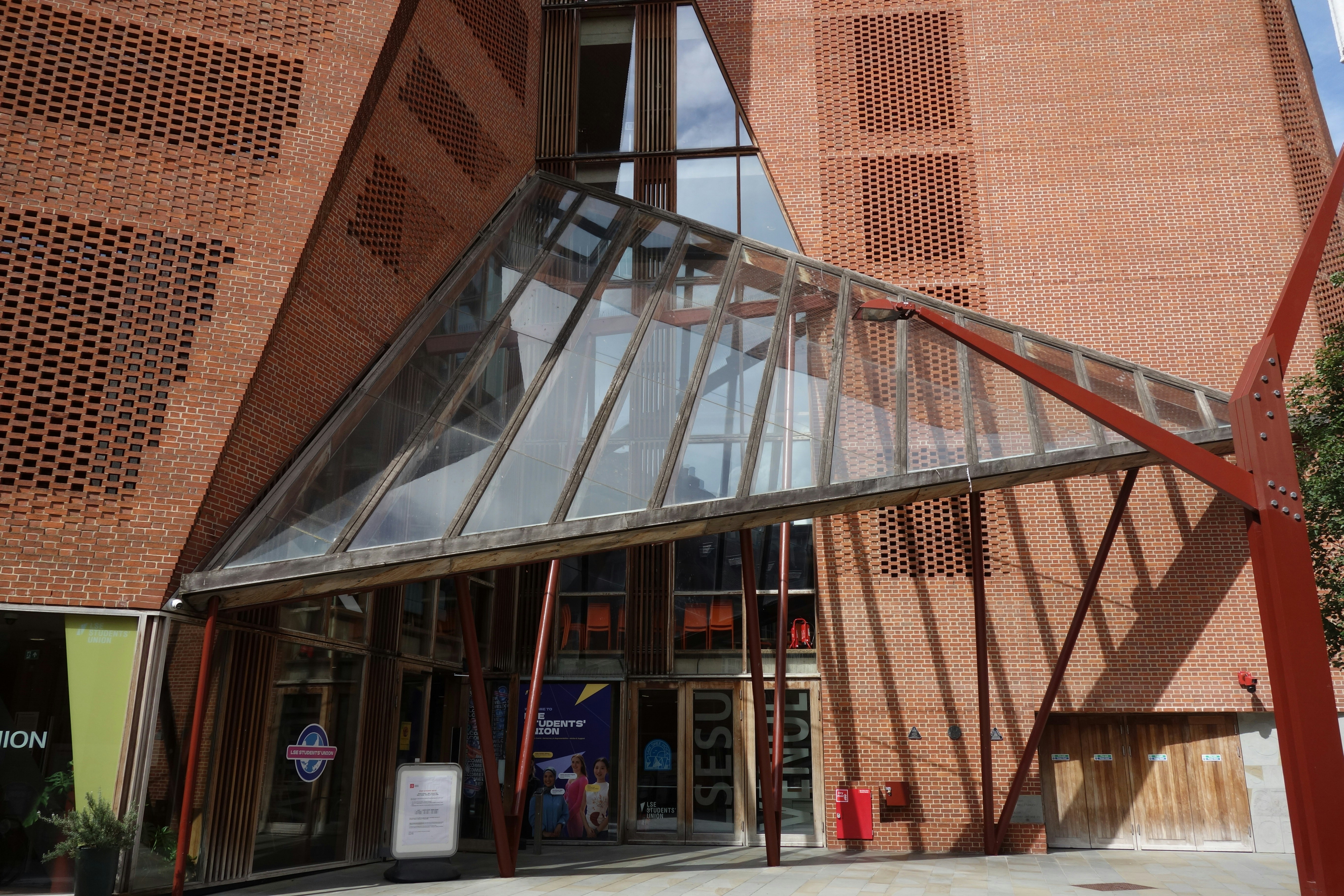 Modern brick public building with a large glass entrance canopy