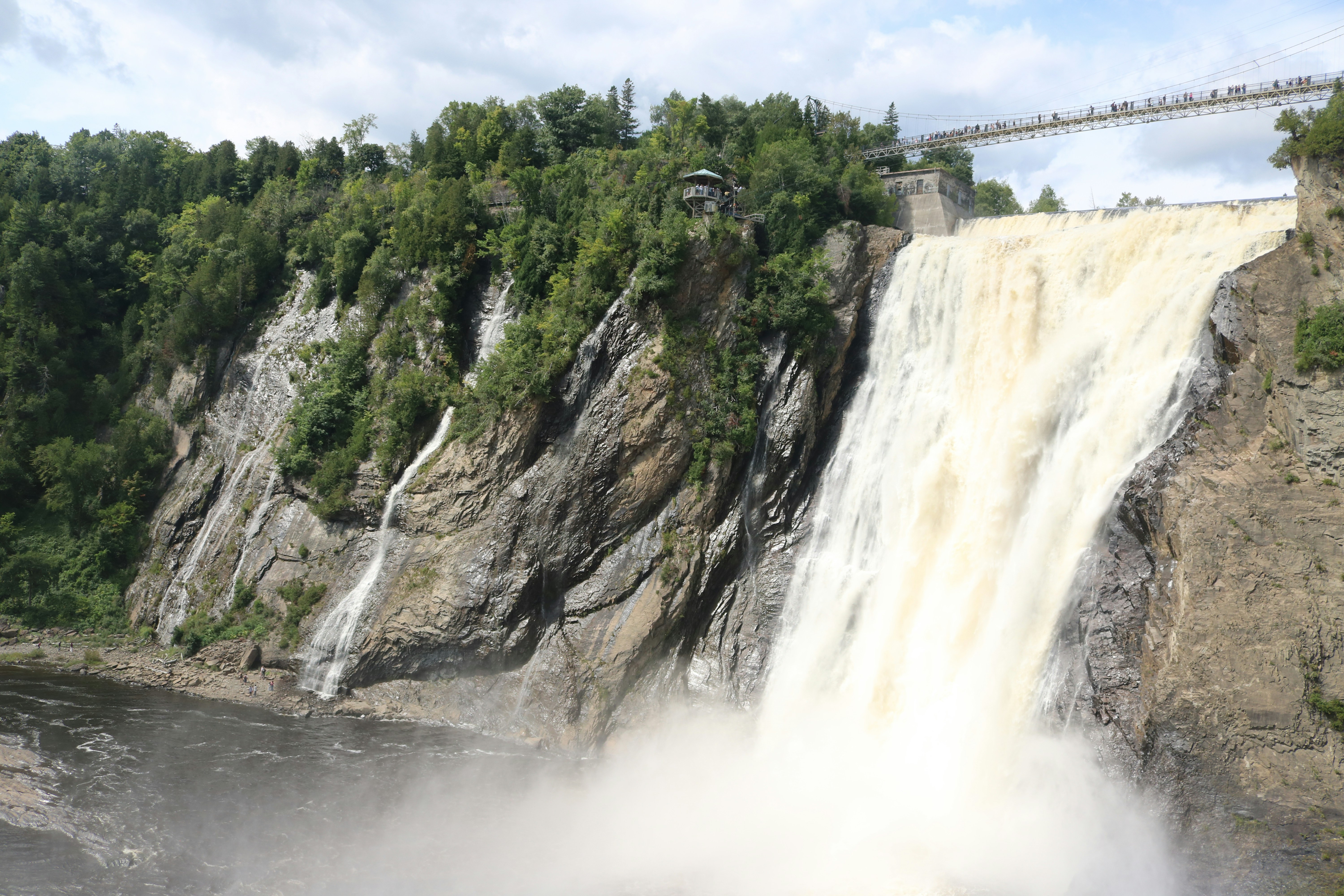 Montmorency Falls cascading over a rocky cliff with a suspension bridge above