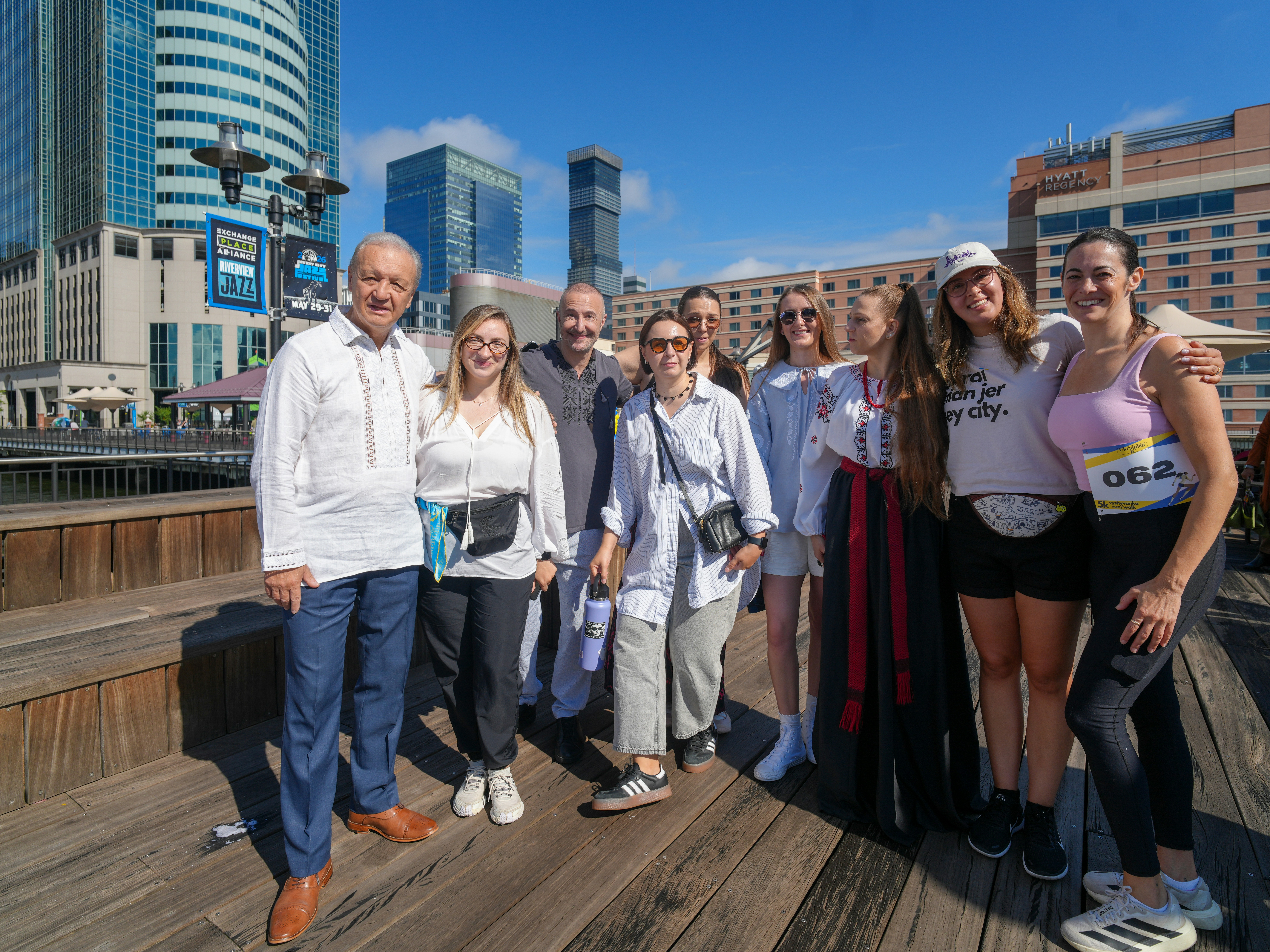 A group of people standing on a wooden boardwalk in Jersey City
