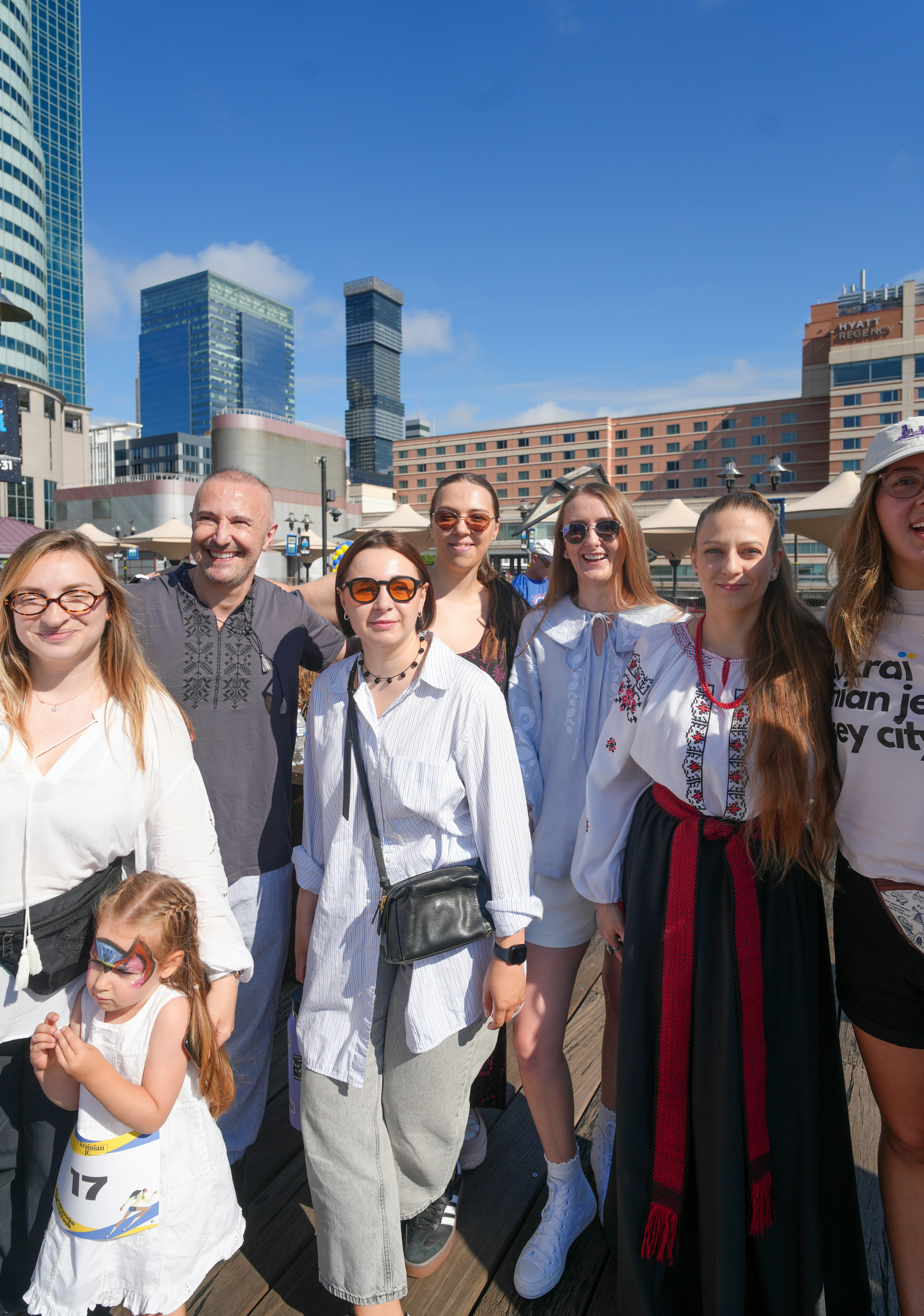A group of people standing on a wooden boardwalk in a city