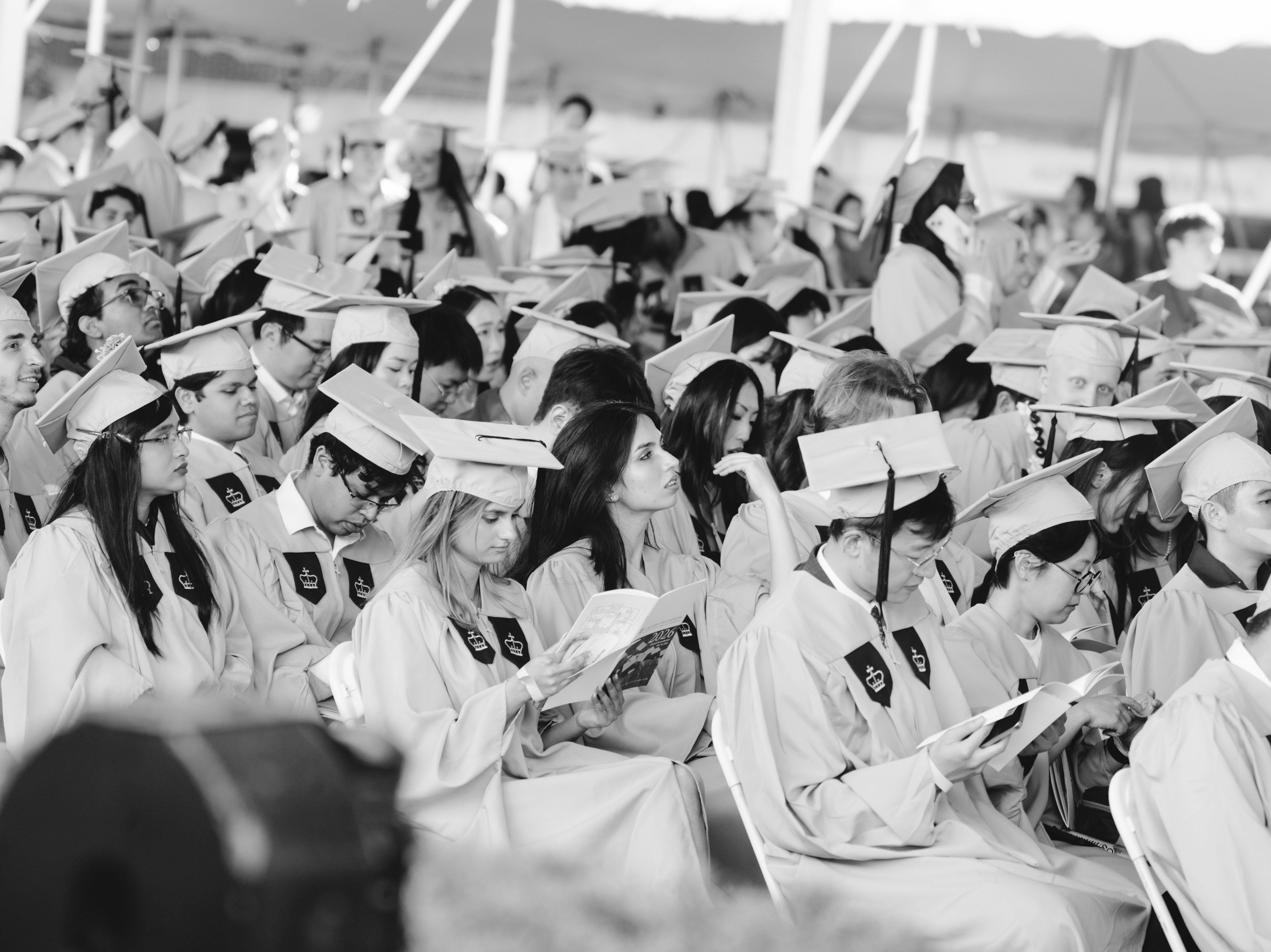 컬럼비아 대학교 졸업식에서 학사모와 가운을 입고 앉아 있는 졸업생들