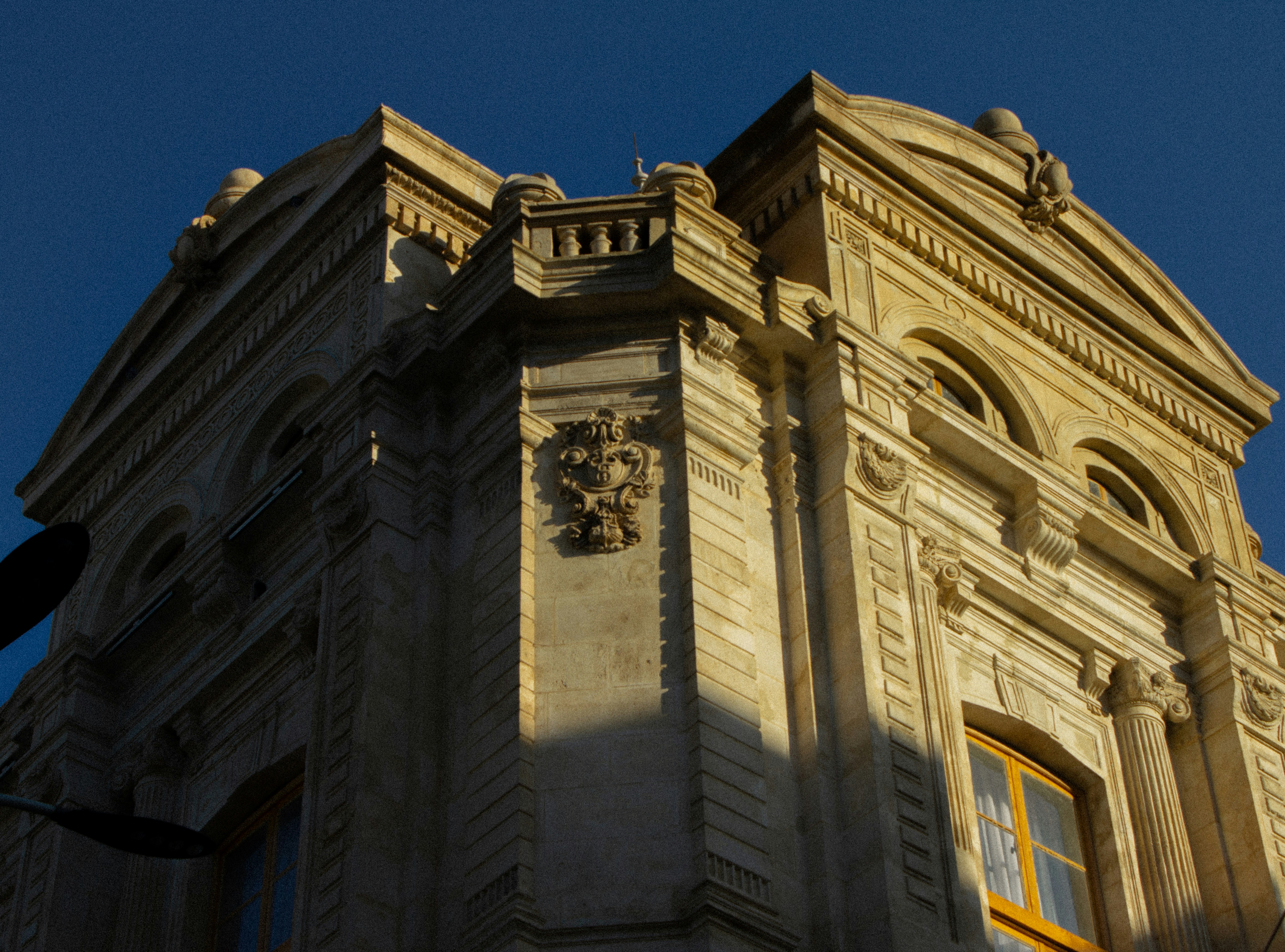 Ornate stone facade of a historic building under a clear deep blue sky