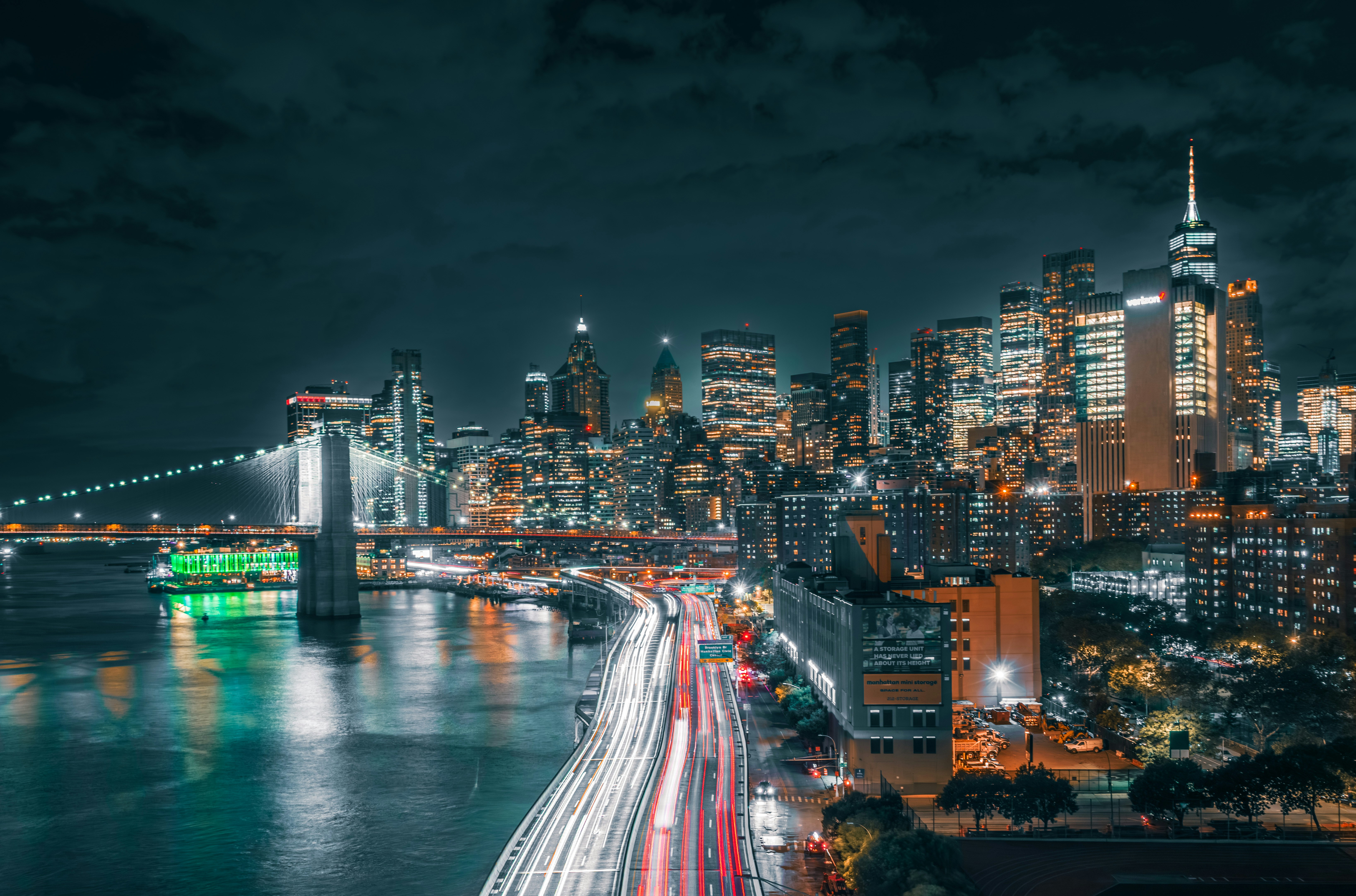 Il Ponte di Brooklyn e lo skyline illuminato di New York di notte con scie di luce