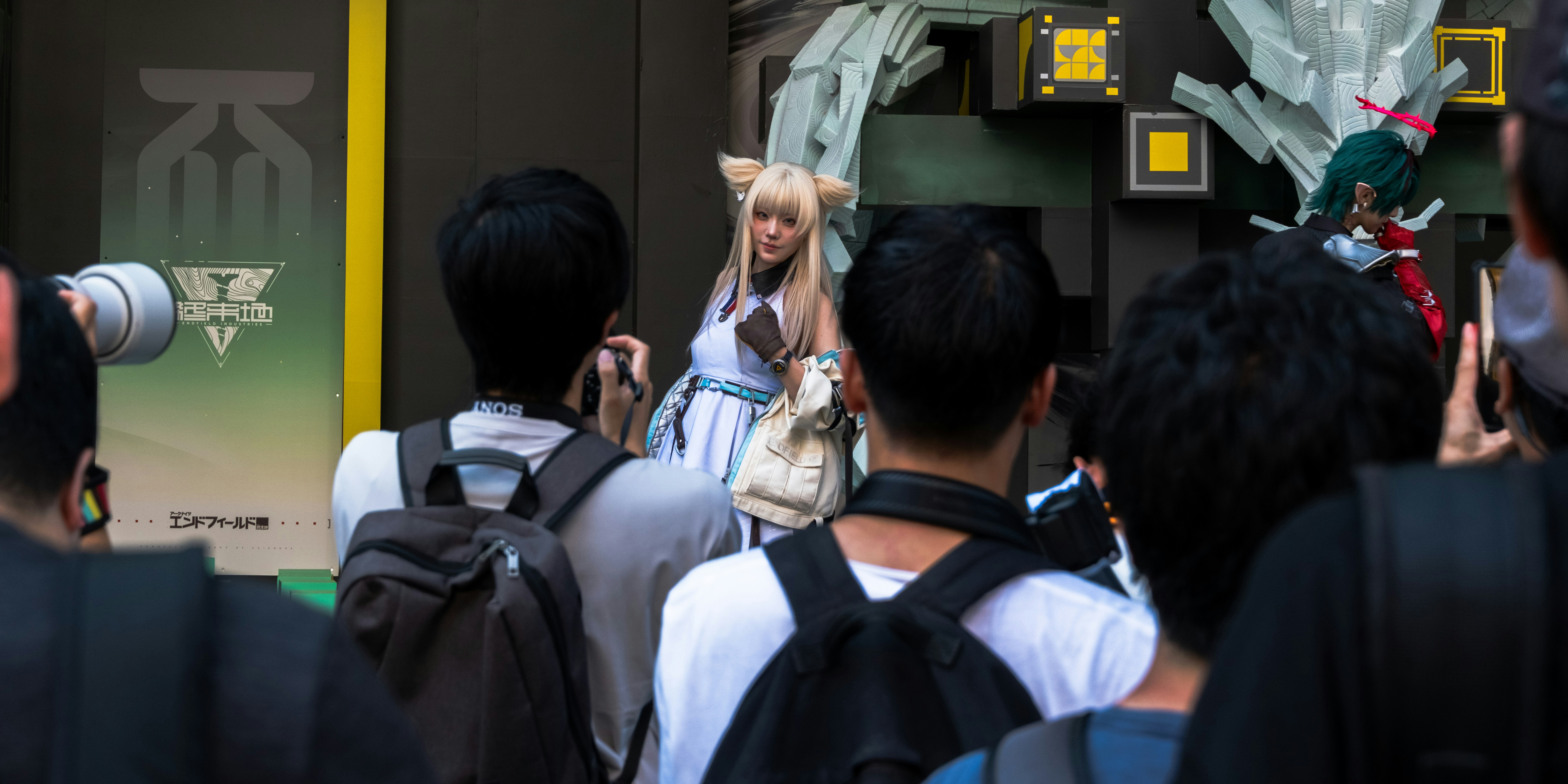 A crowd of people photographing a woman in a white cosplay outfit