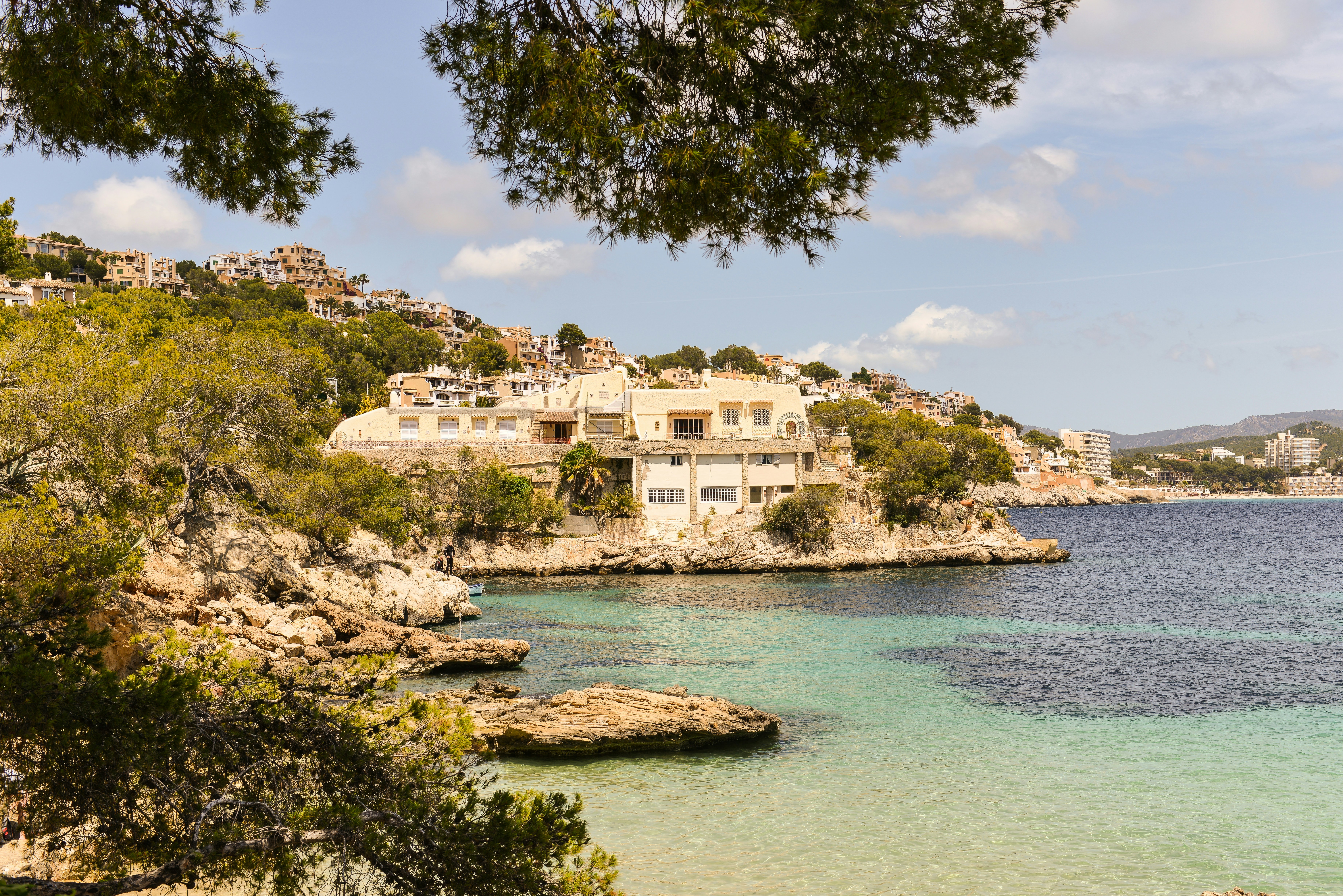 A large villa on a rocky coastline overlooking turquoise water in Mallorca