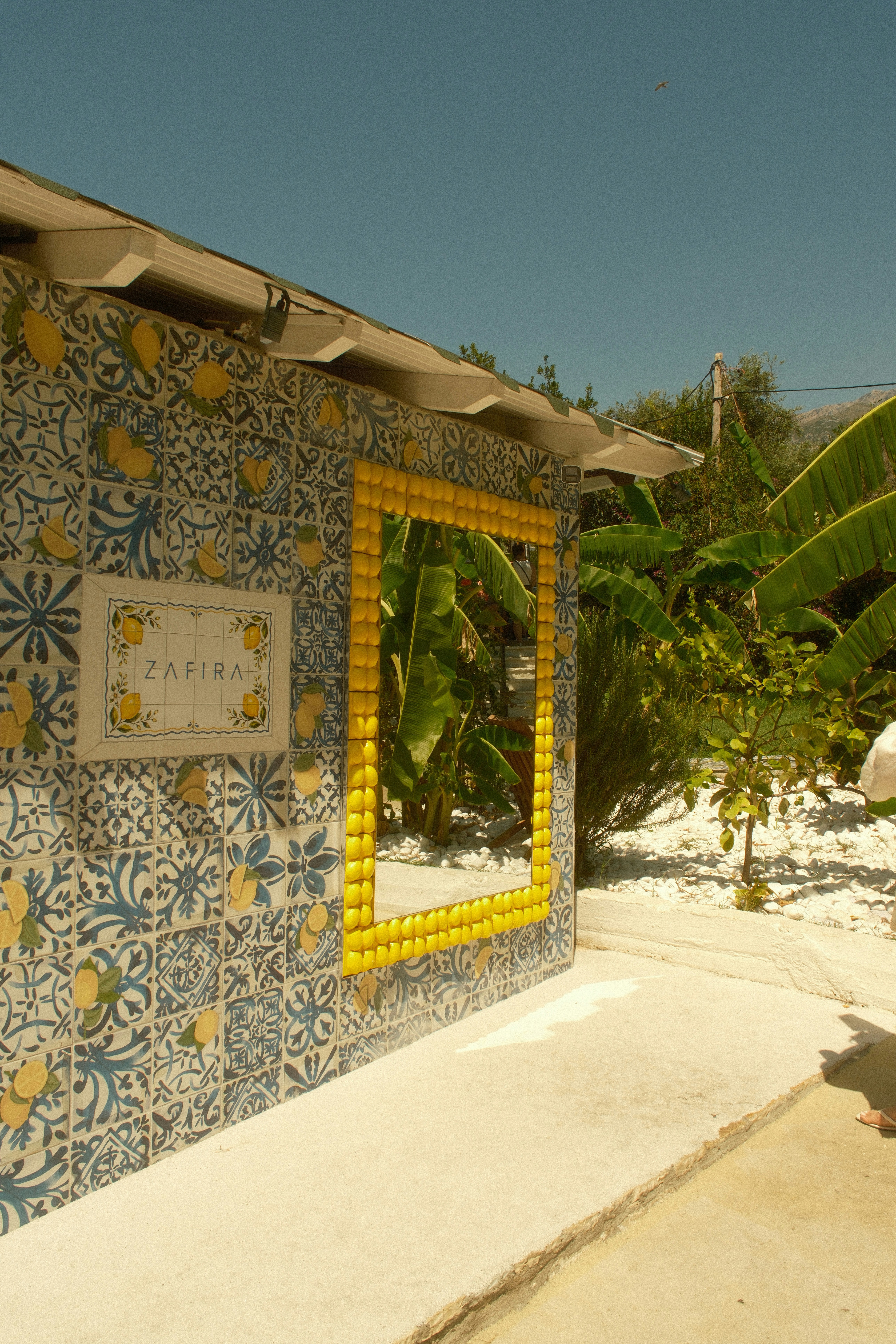 A wall with blue and white patterned tiles and a yellow lemon frame