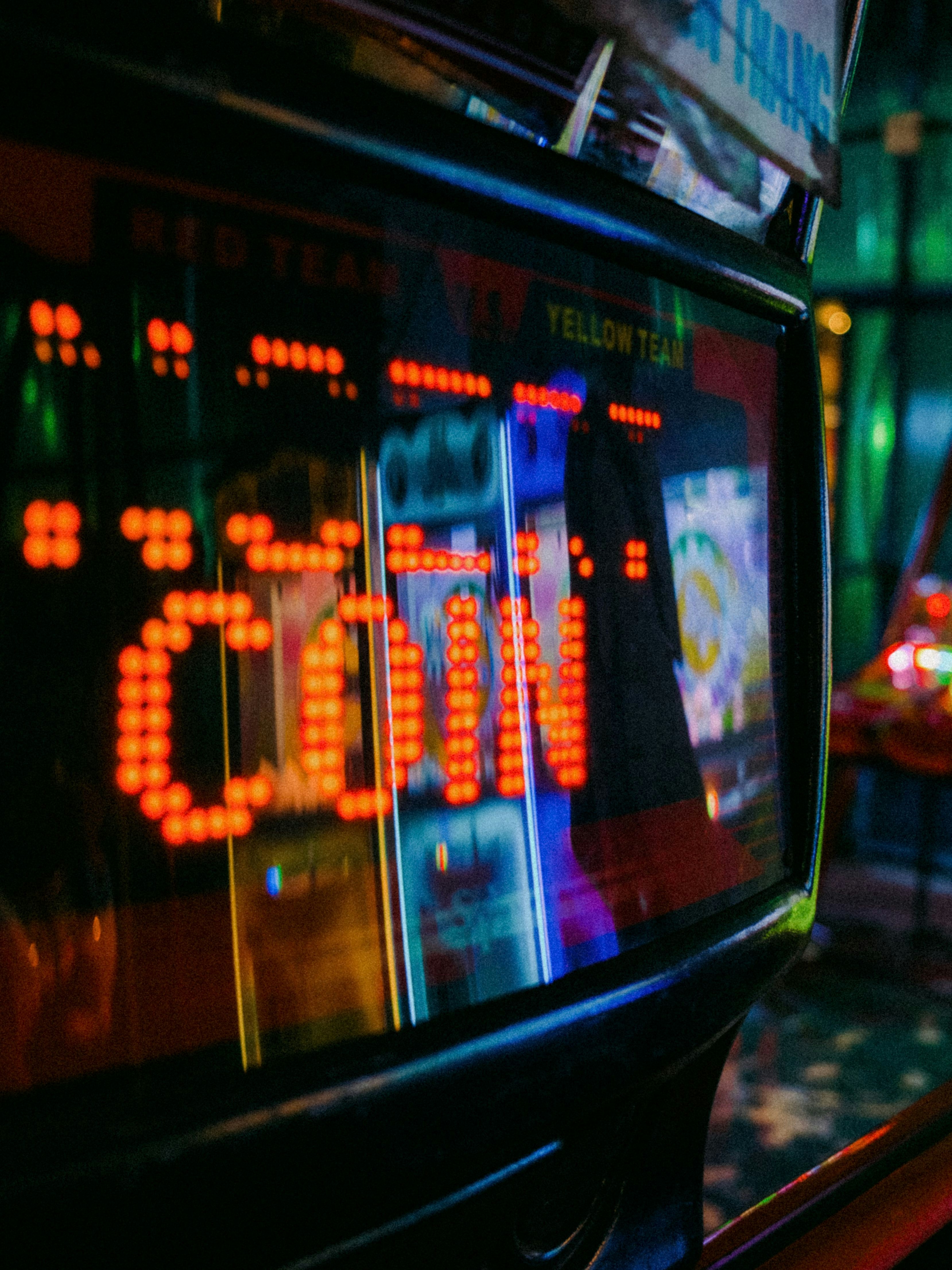 A glowing red coin display on an arcade machine screen in a dark room