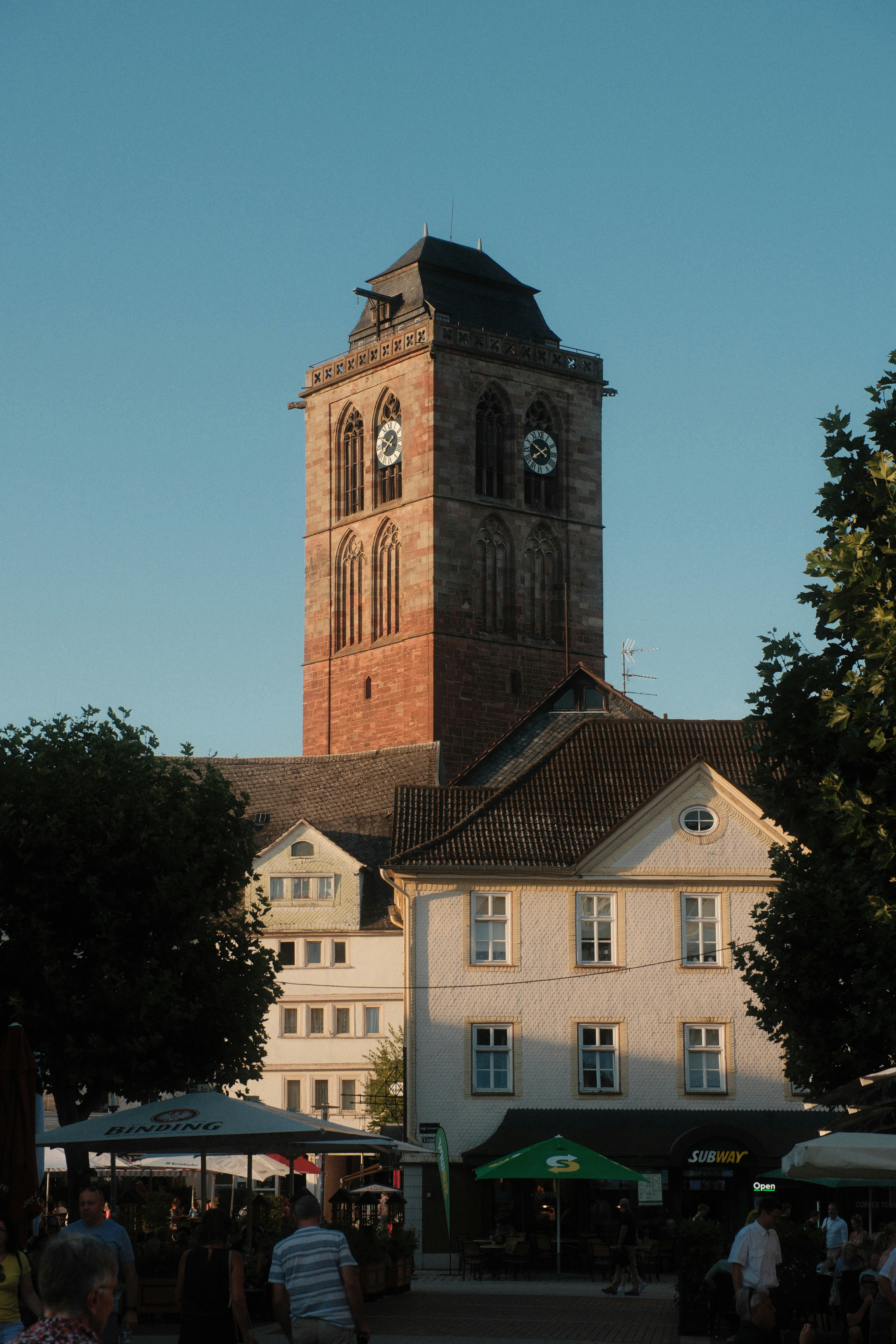 A tall stone clock tower rising above buildings in a town square