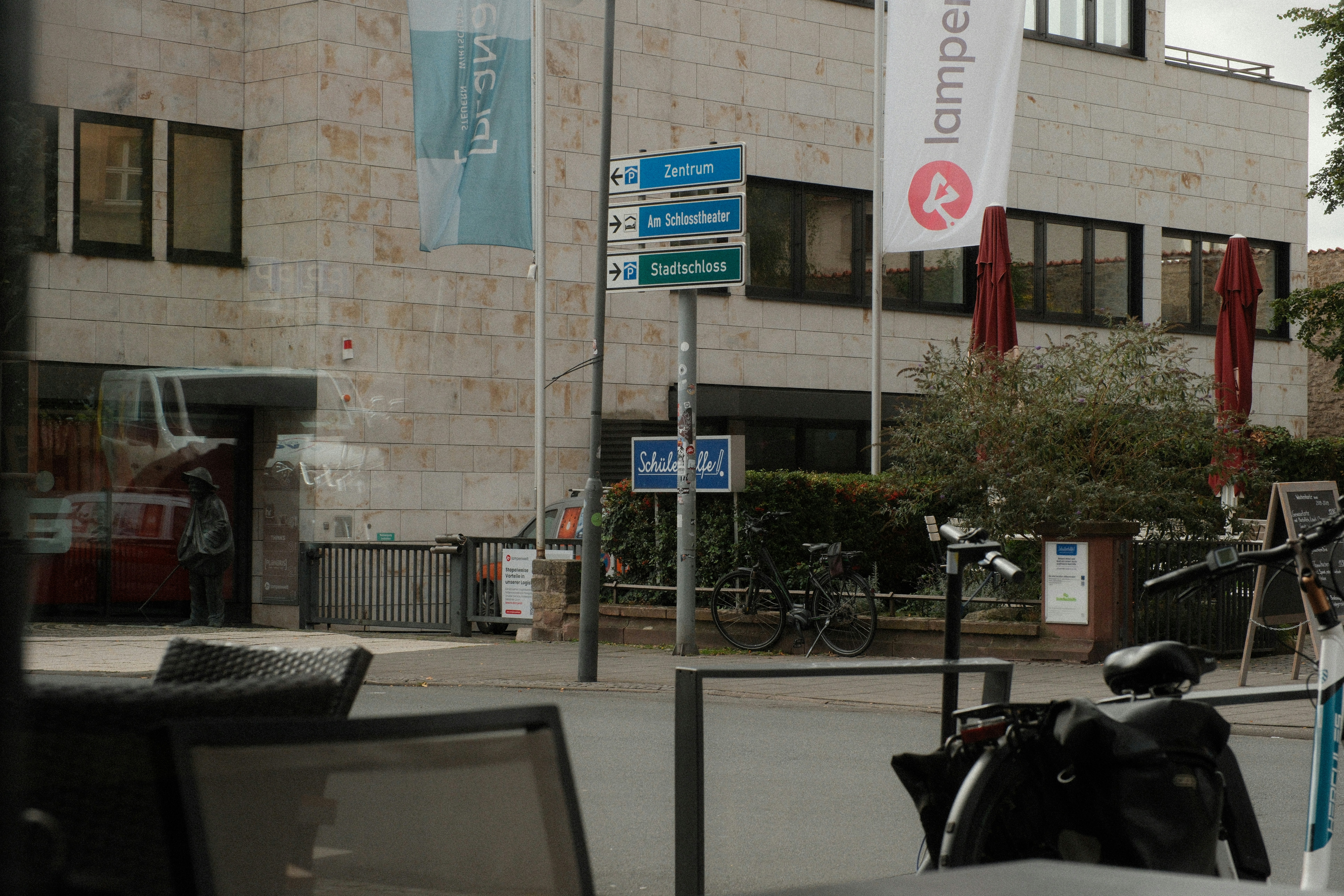 Directional signs for Zentrum and Stadtschloss on a pole in a city square