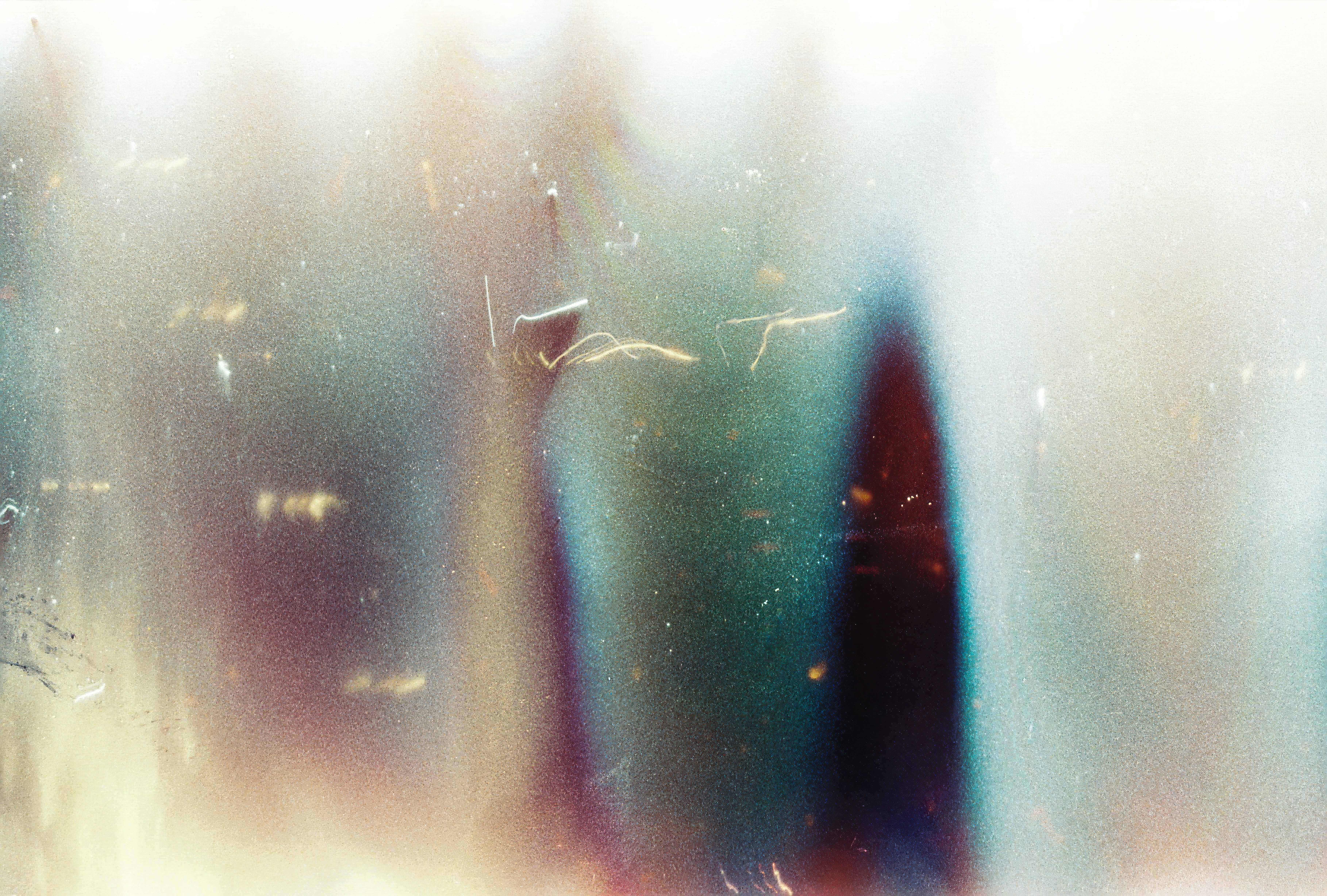Abstract light leaks and film grain texture with blue and dark red tones