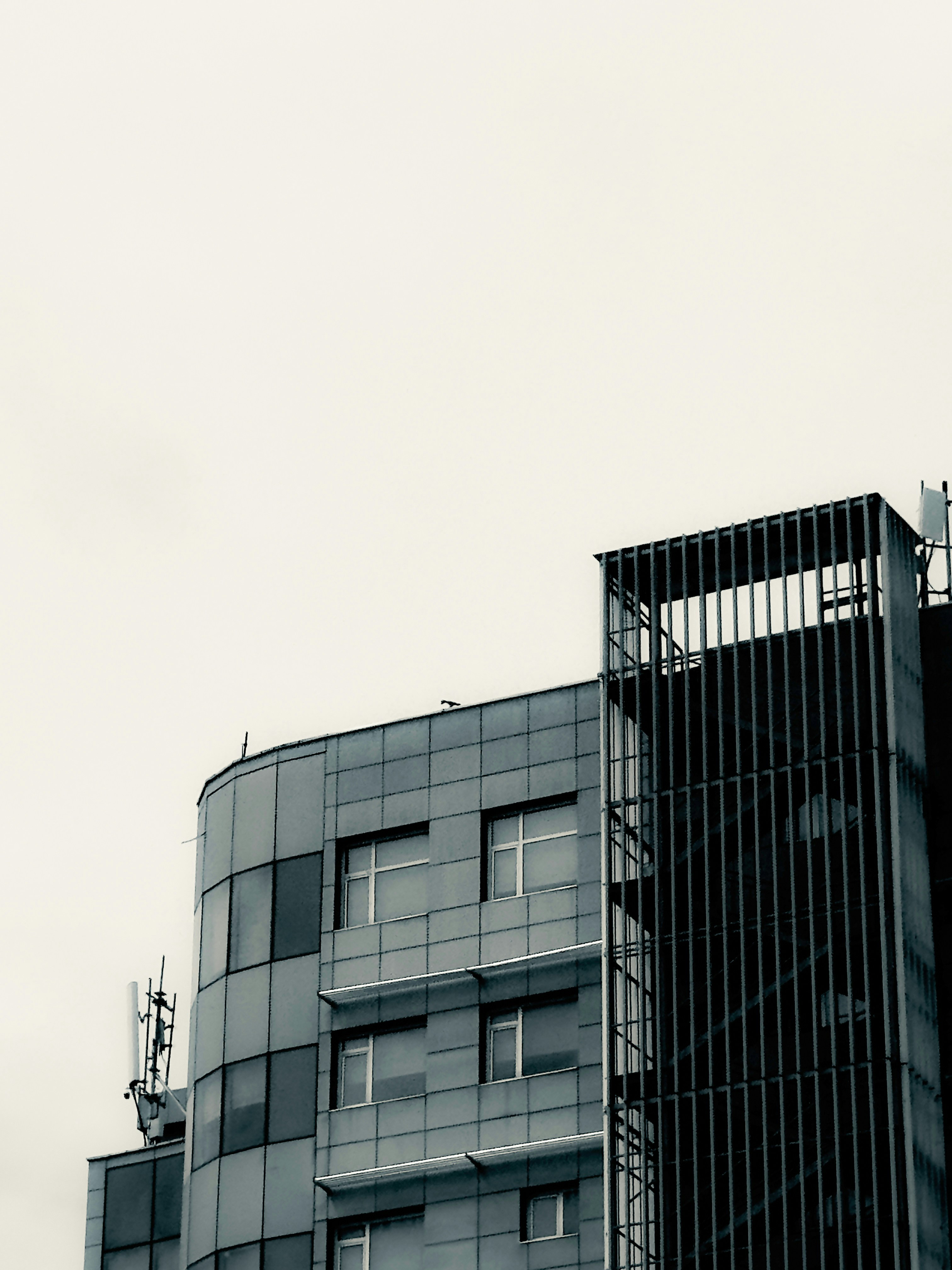 A modern office building with grey metal panels and a vertical stairwell screen