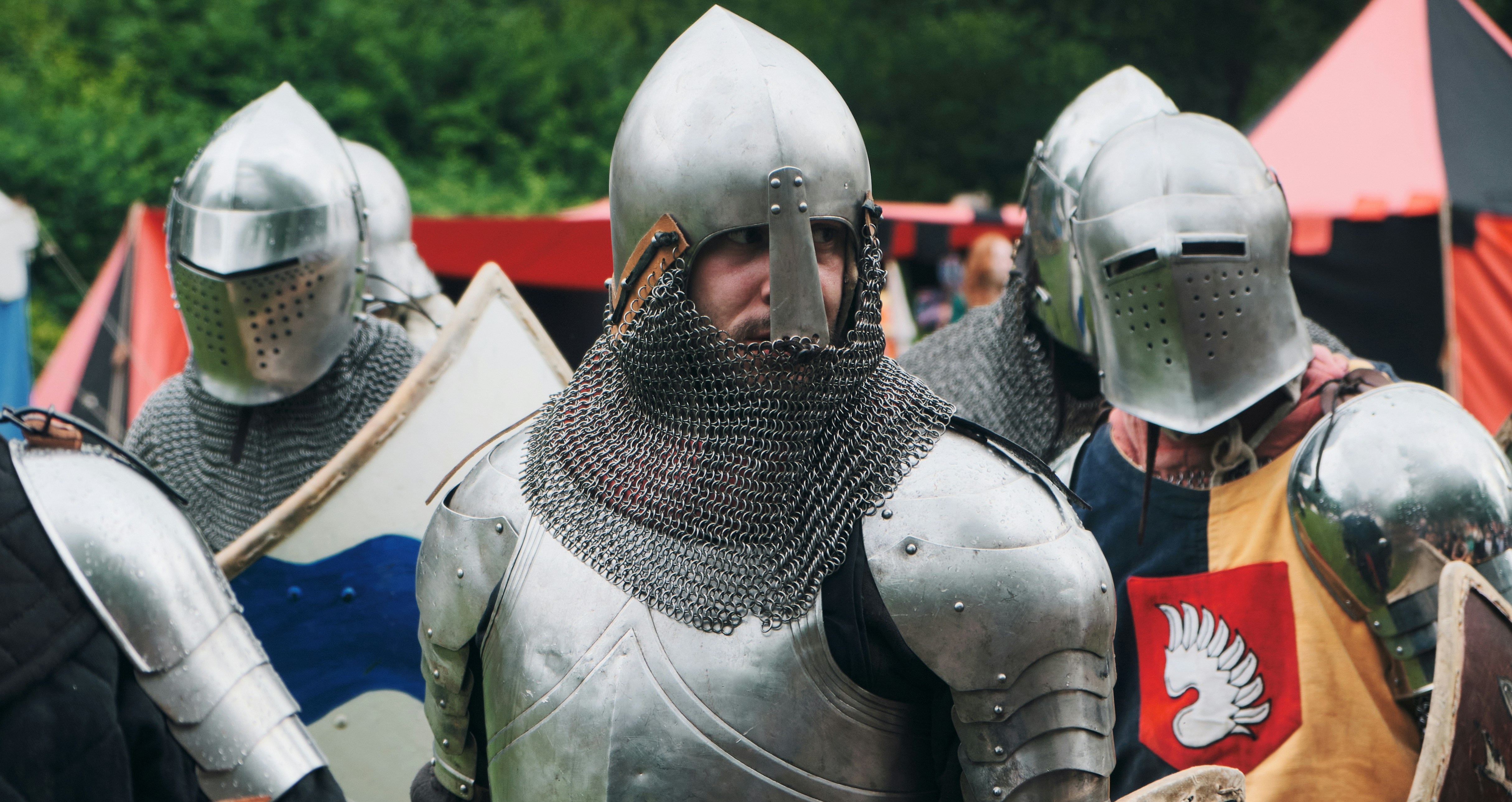 Um grupo de pessoas com armaduras de aço medieval e cota de malha em uma reencenação