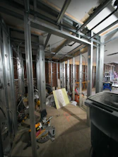 Metal wall studs in a room under construction with exposed brick walls