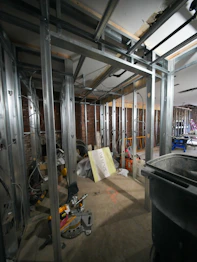 Metal wall studs in a room under construction with exposed brick walls