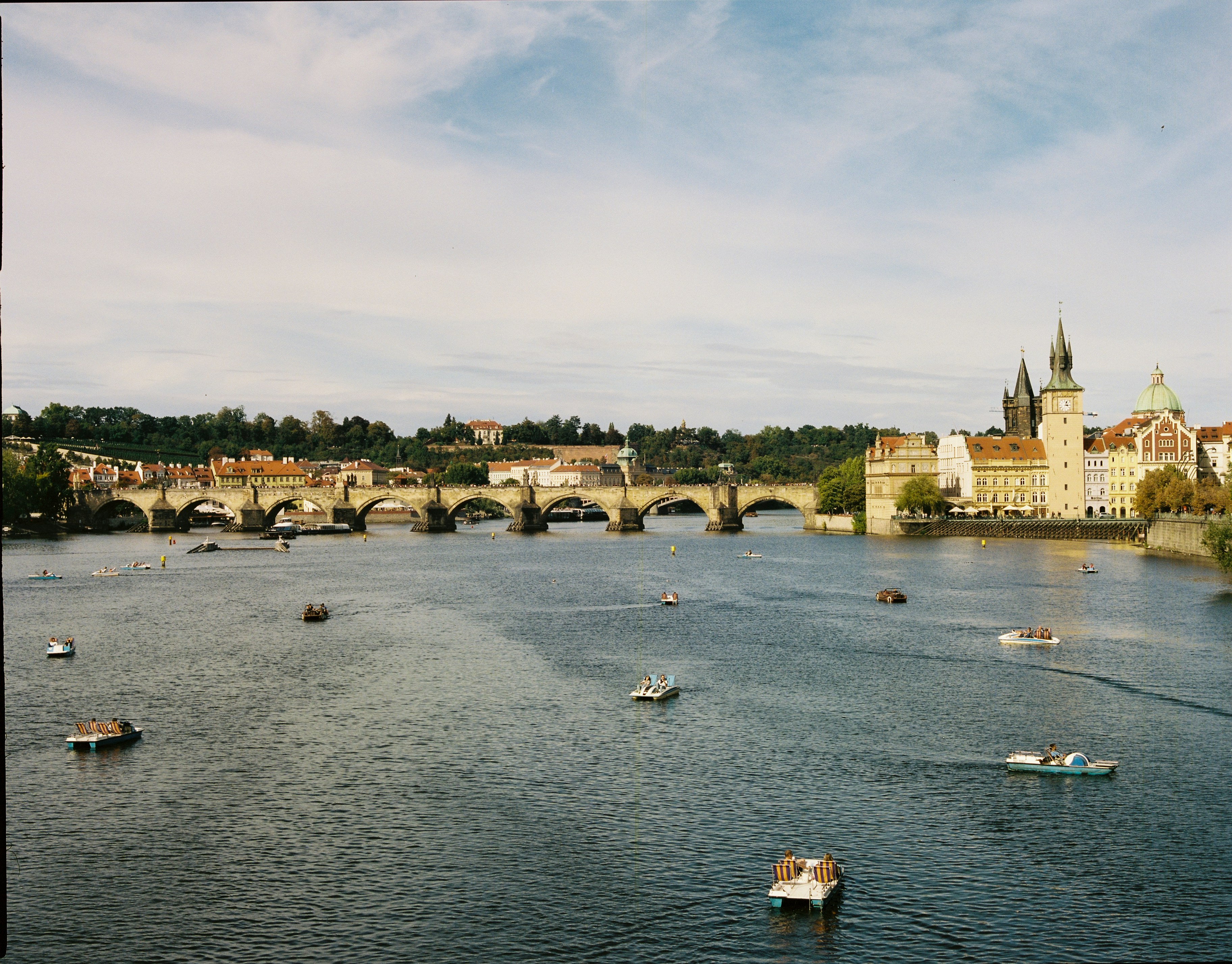 Charles Bridge over the Vltava River with pedal boats in Prague