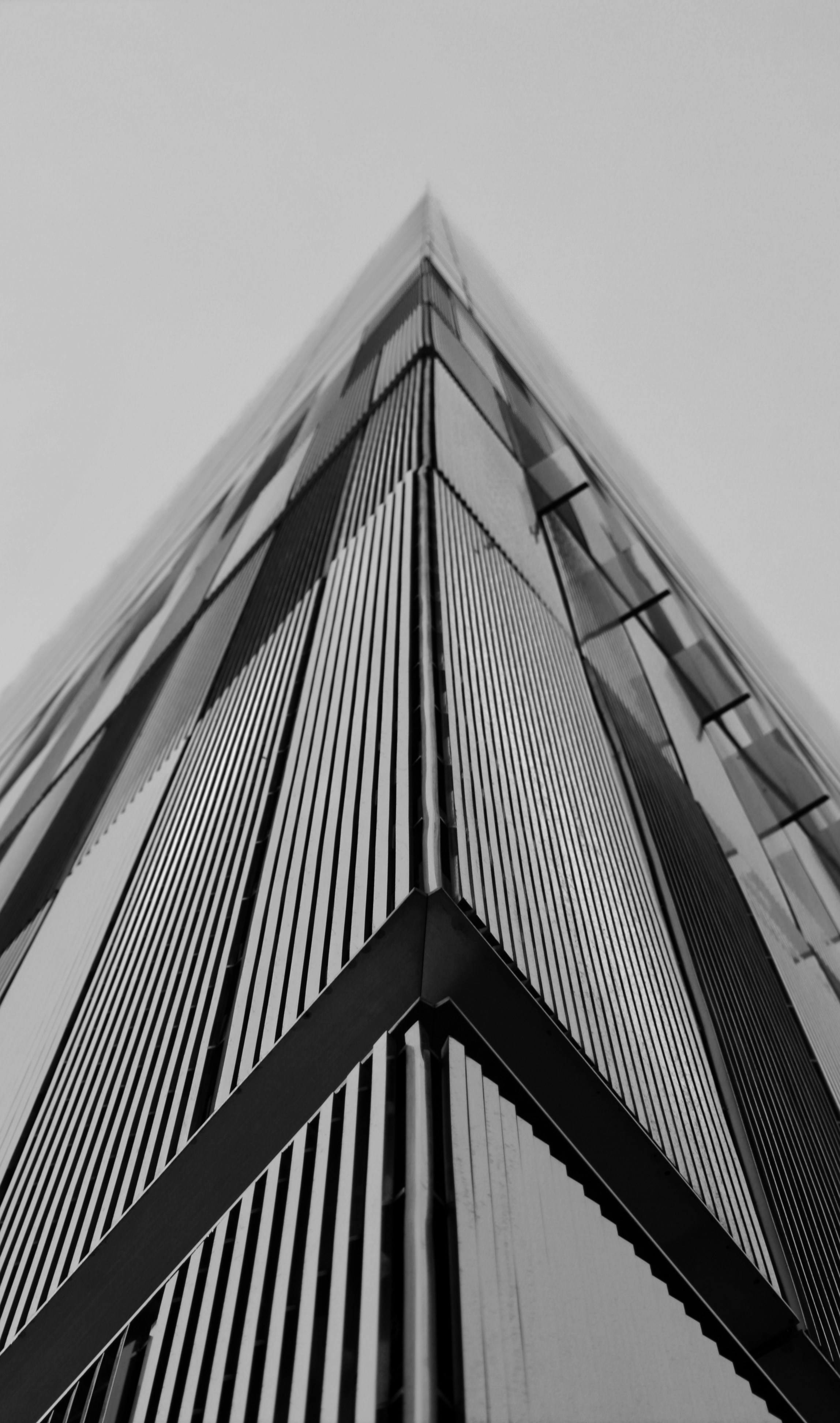A low angle view of a modern skyscraper corner with vertical metal fins