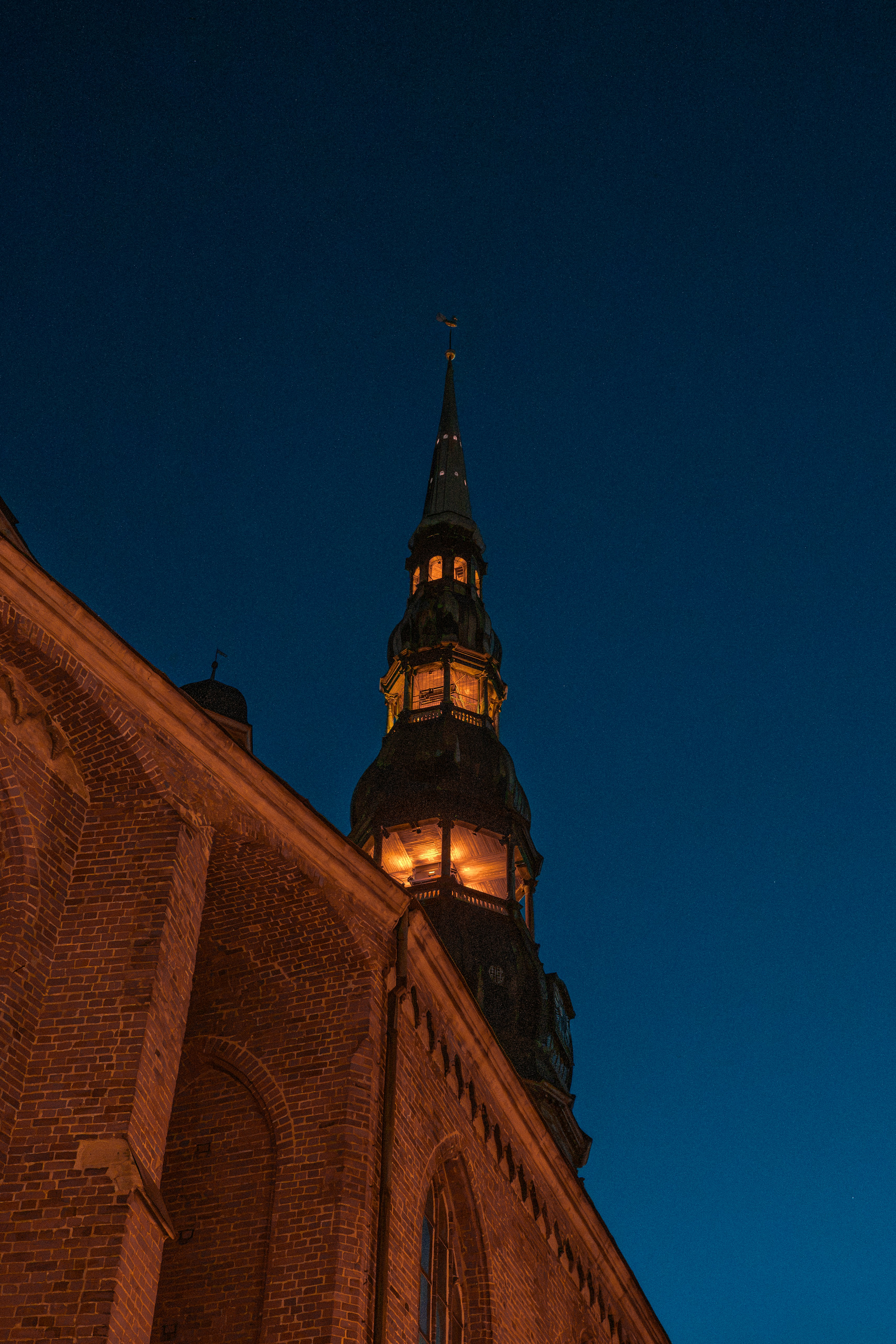 The illuminated spire of St. Peter's Church against a deep blue night sky