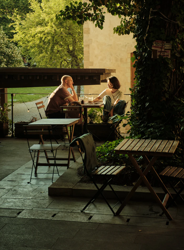 A couple at a table on a sunlit patio at golden hour