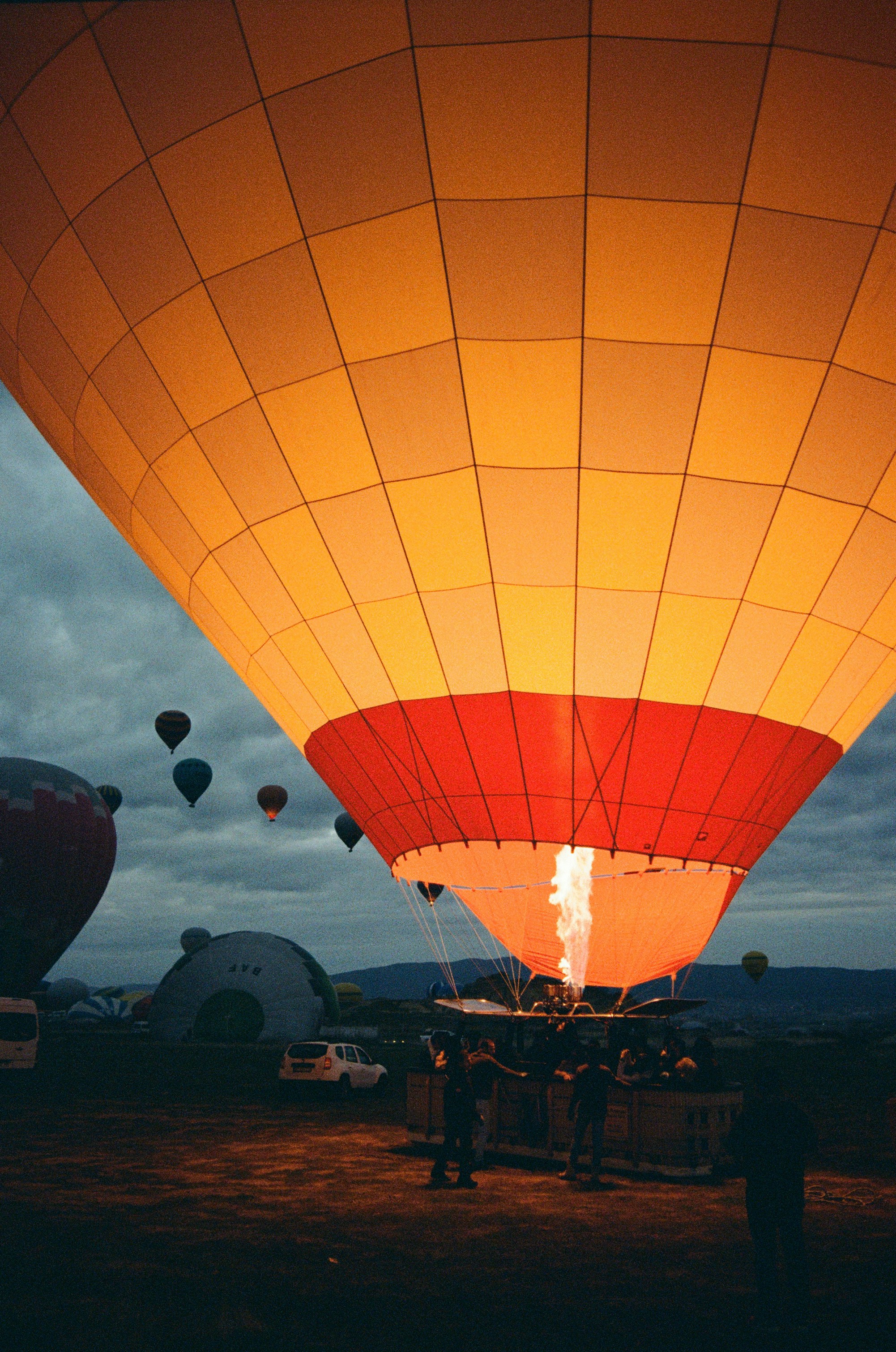 A hot air balloon with a glowing burner above a basket at night
