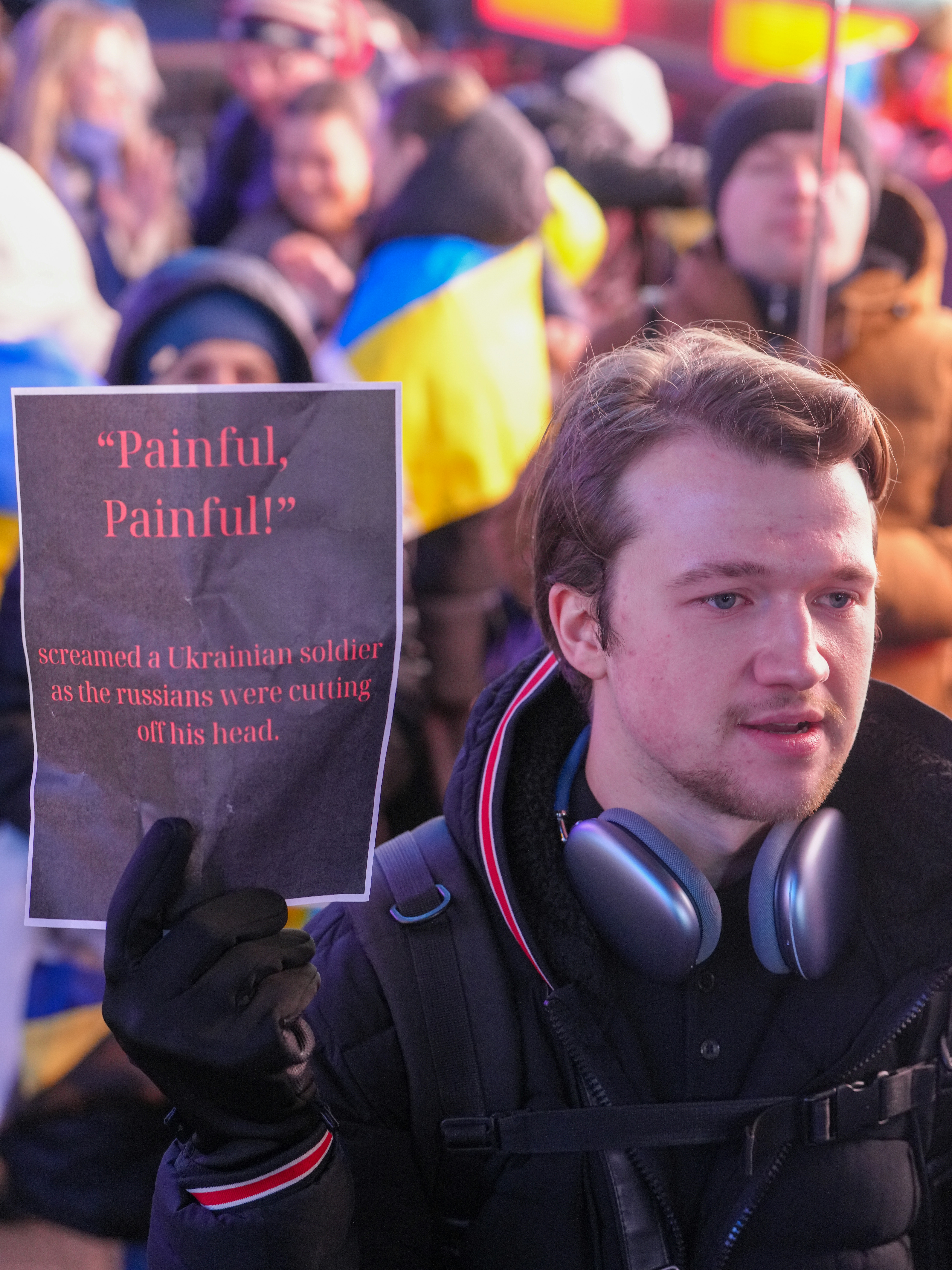 A person holding a sign with red text in a crowd