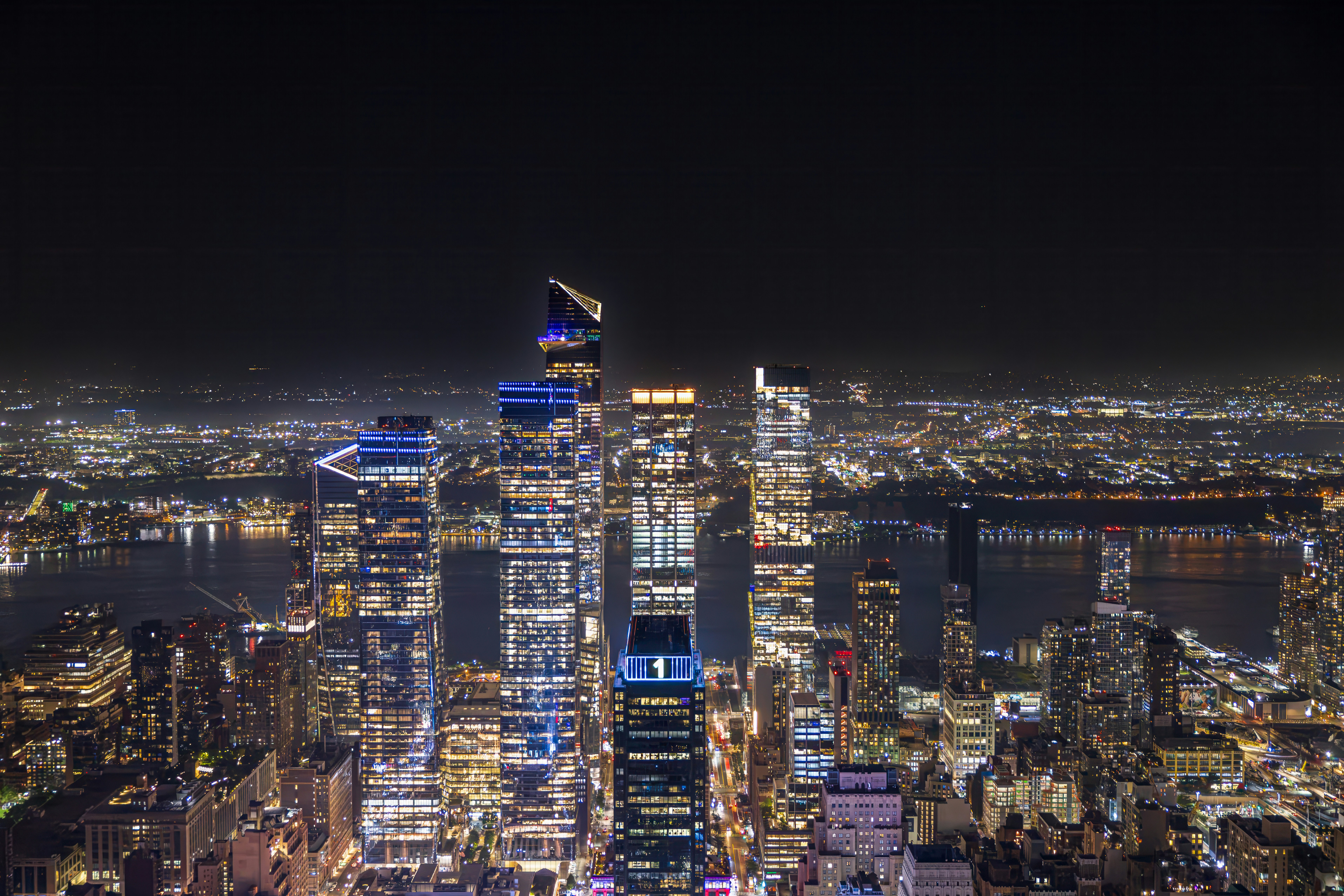 Illuminated skyscrapers of Hudson Yards at night overlooking the Hudson River in New York