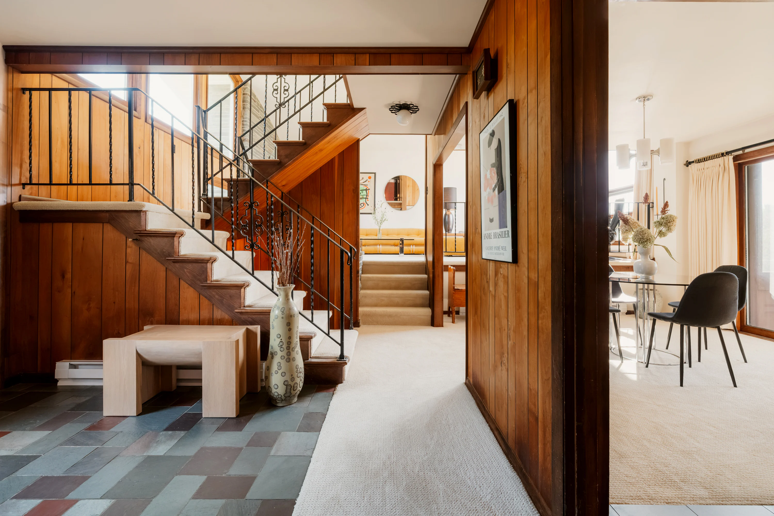 A wooden staircase with iron railings in a mid-century modern home interior