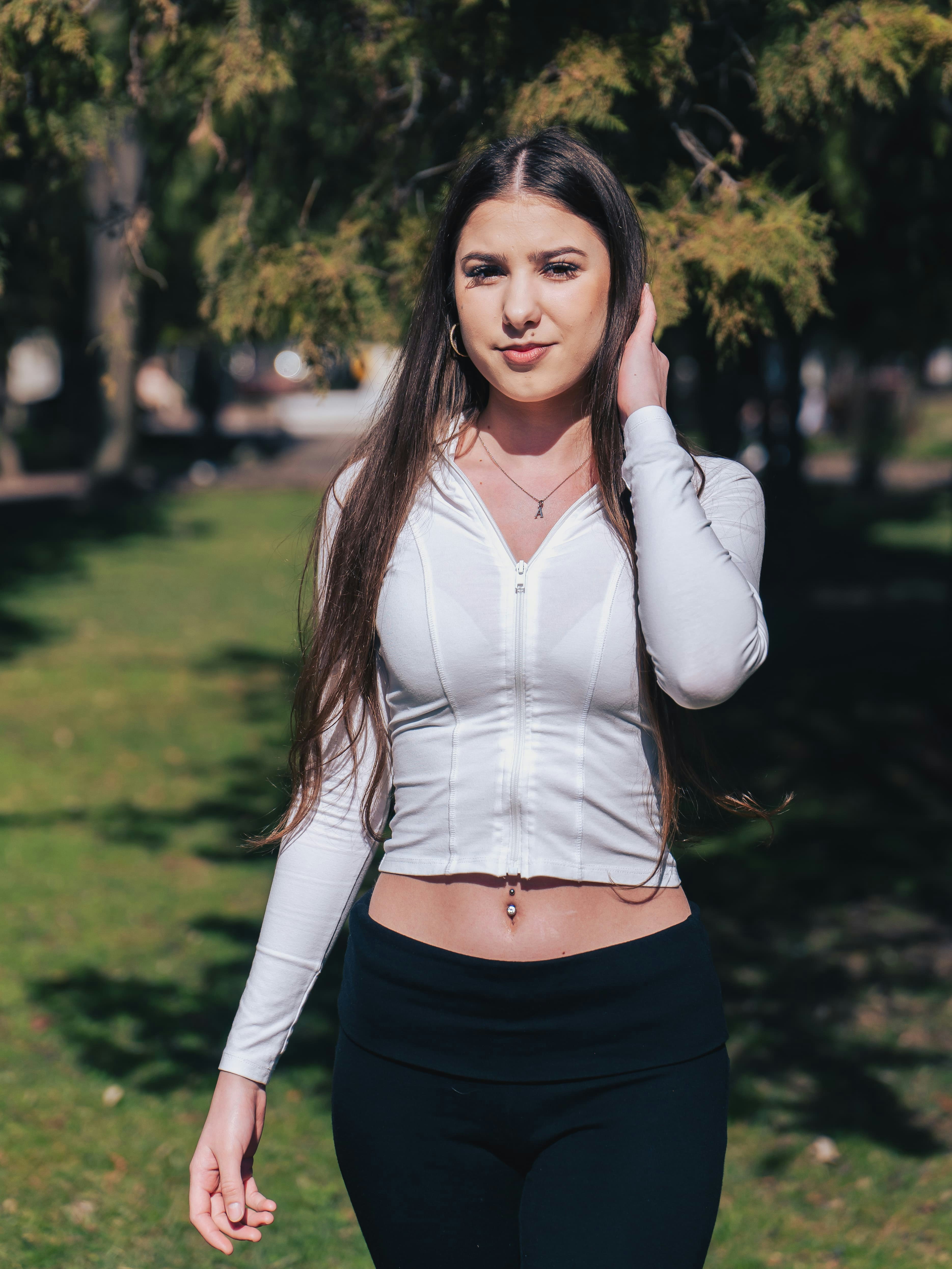 A woman in a white zip-up top and black leggings in a park